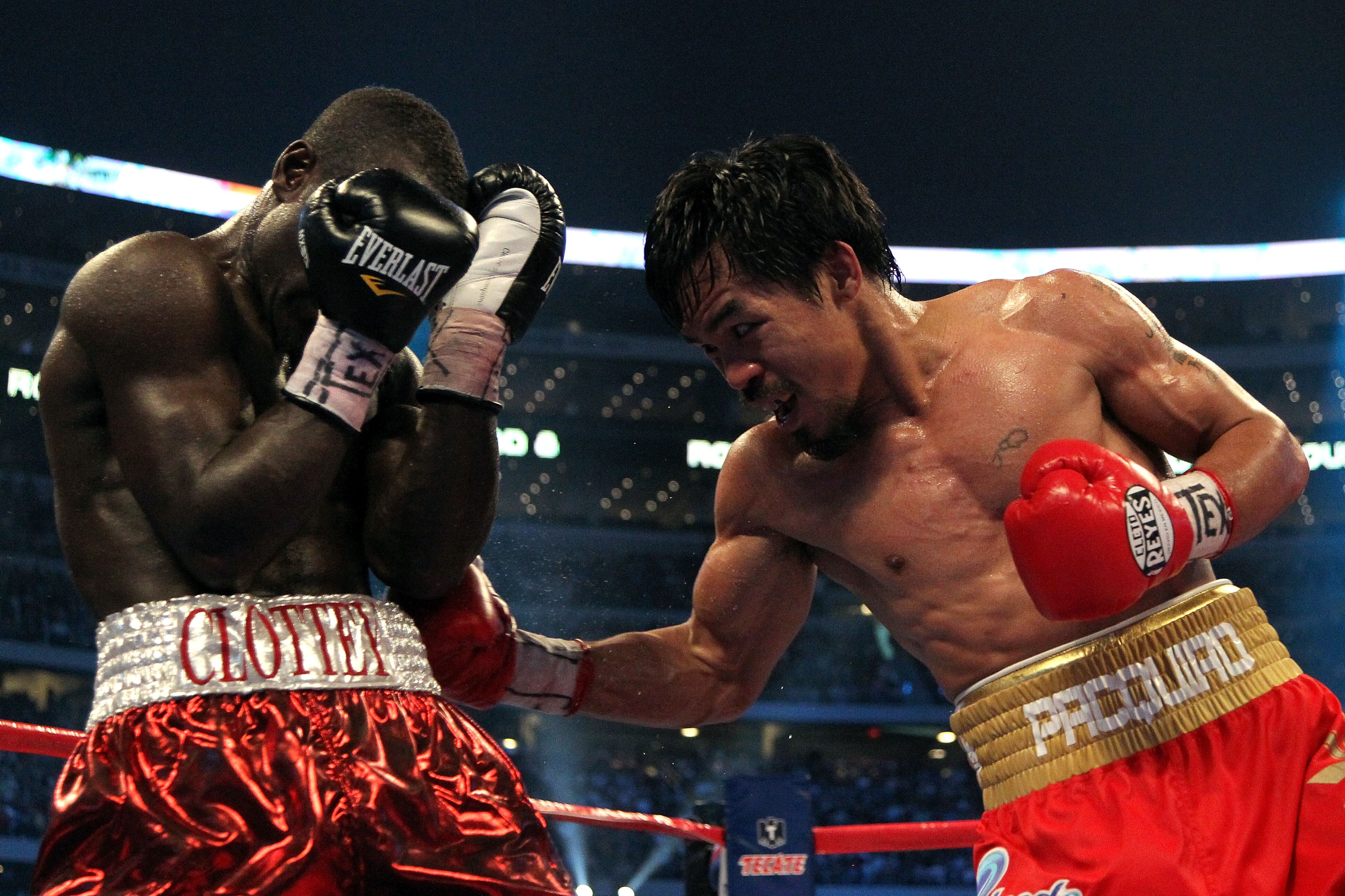 ARLINGTON, TX - MARCH 13:  (R-L) Manny Pacquiao of the Philippines throws a right to the body of Joshua Clottey of Ghana during the WBO welterweight title fight at Cowboys Stadium on March 13, 2010 in Arlington, Texas. Pacquiao defeated Clottey by unanimo