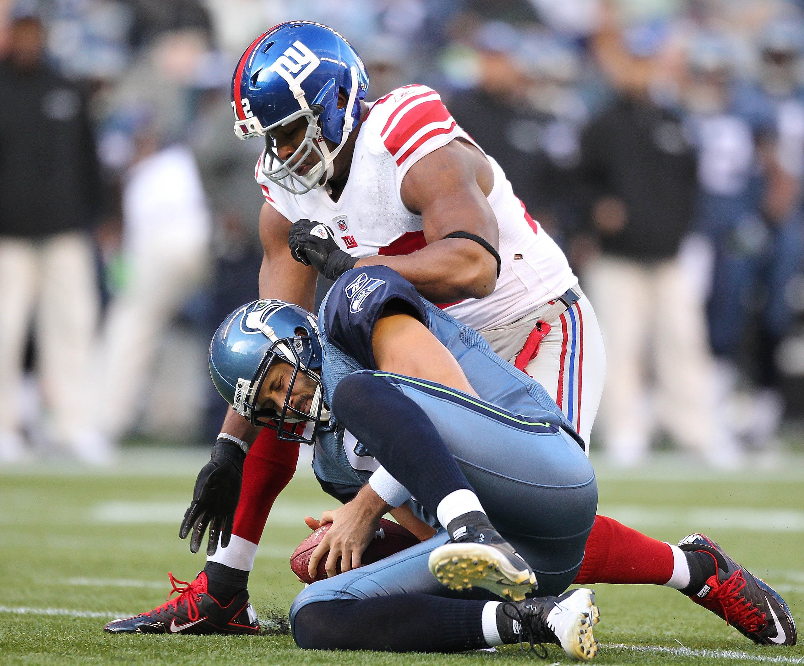 SEATTLE - NOVEMBER 07:  Quarterback Charlie Whitehurst #6 of the Seattle Seahawks is tackled by Osi Umenyiora #72 of the New York Giants after recovering his own fumble at Qwest Field on November 7, 2010 in Seattle, Washington. The Giants defeated the Sea