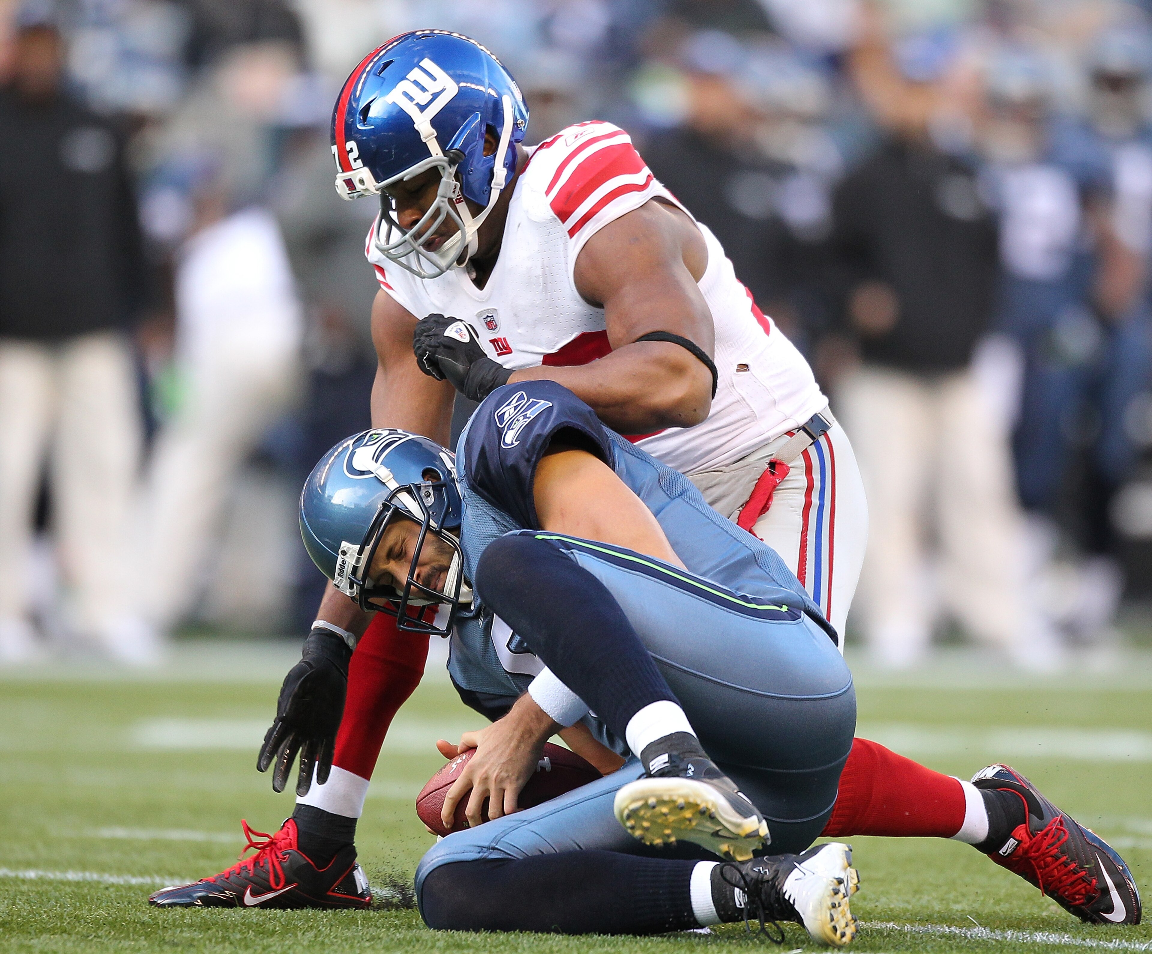 SEATTLE - NOVEMBER 07:  Quarterback Charlie Whitehurst #6 of the Seattle Seahawks is tackled by Osi Umenyiora #72 of the New York Giants after recovering his own fumble at Qwest Field on November 7, 2010 in Seattle, Washington. The Giants defeated the Sea