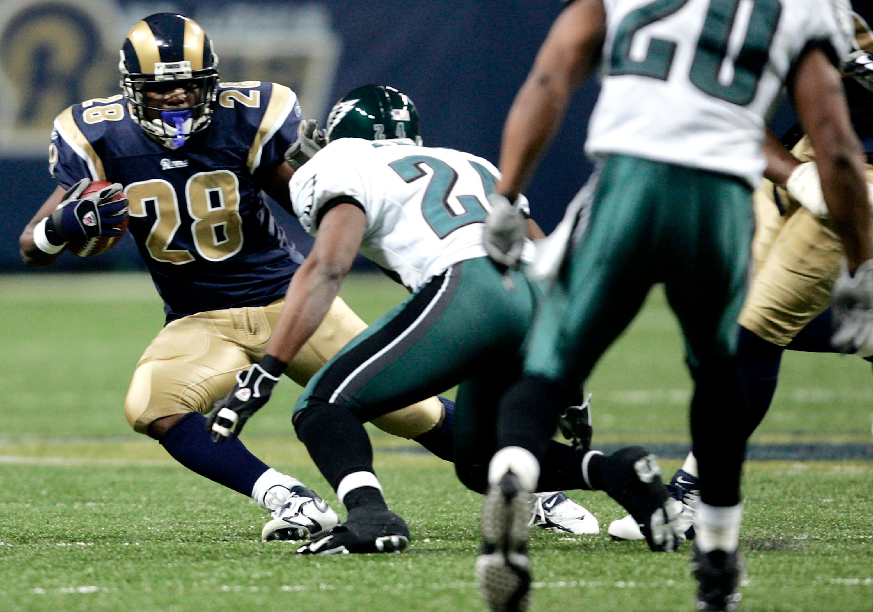 ST. LOUIS - DECEMBER 18:  Marshall Faulk #28 of the St. Louis Rams looks to get by Sheldon Brown #24 of the Philadelphia Eagles  at the Edward Jones Dome on December 18, 2005 in St. Louis, Missouri.  (Photo by Dilip Vishwanat/Getty Images)