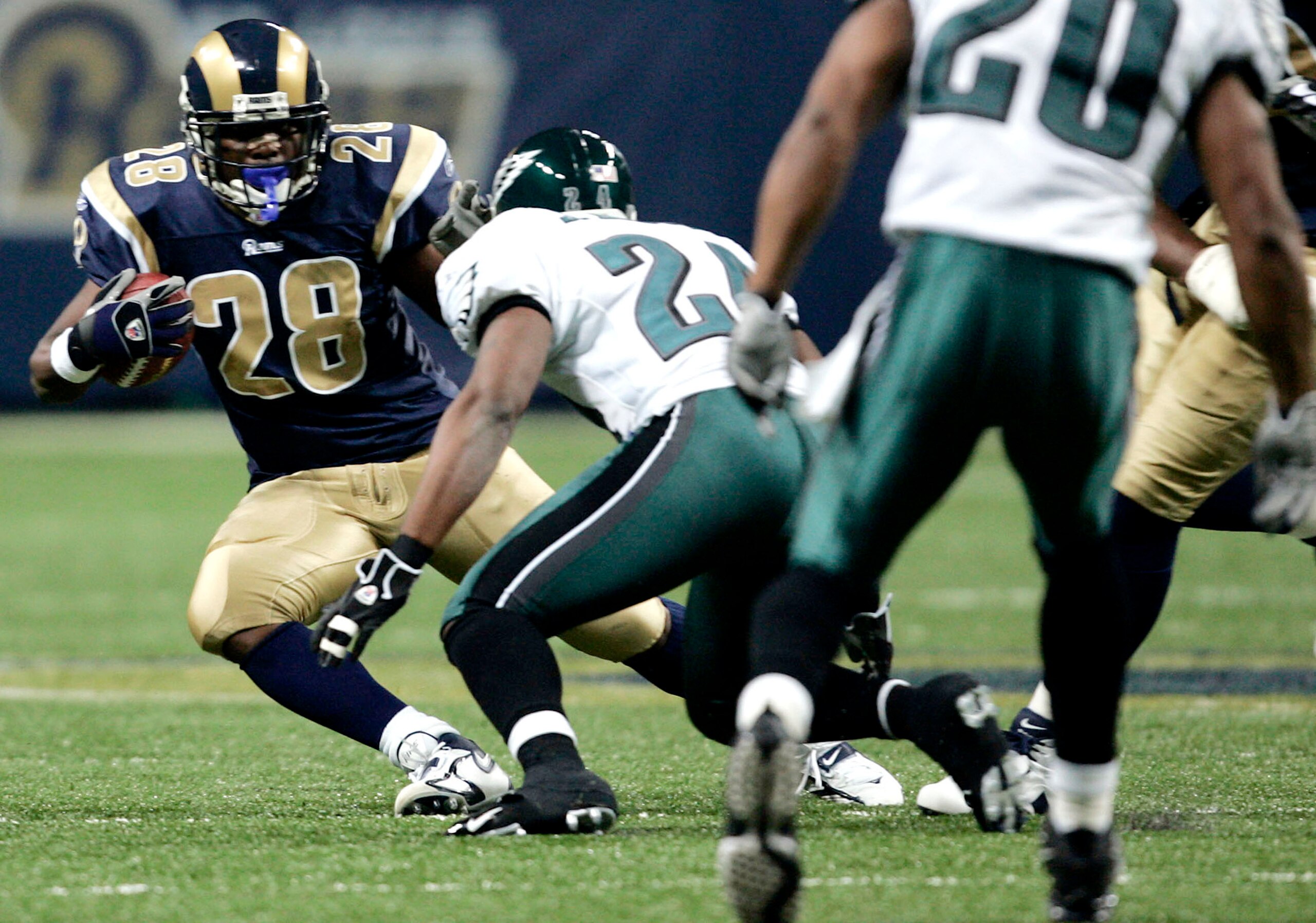 ST. LOUIS - DECEMBER 18:  Marshall Faulk #28 of the St. Louis Rams looks to get by Sheldon Brown #24 of the Philadelphia Eagles  at the Edward Jones Dome on December 18, 2005 in St. Louis, Missouri.  (Photo by Dilip Vishwanat/Getty Images)