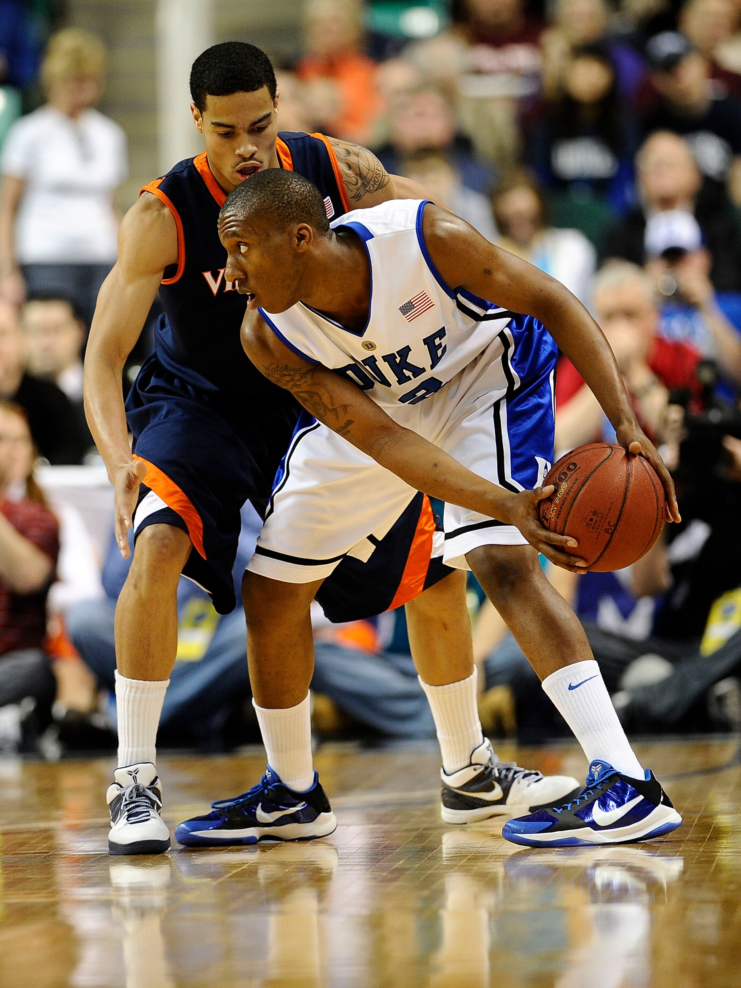 GREENSBORO, NC - MARCH 12:  Nolan Smith #2 of the Duke Blue Devils looks to get by Mike Scott #32 of the University of Virginia Cavaliers in their quarterfinal game in the 2010 ACC Men's Basketball Tournament at the Greensboro Coliseum on March 12, 2010 i
