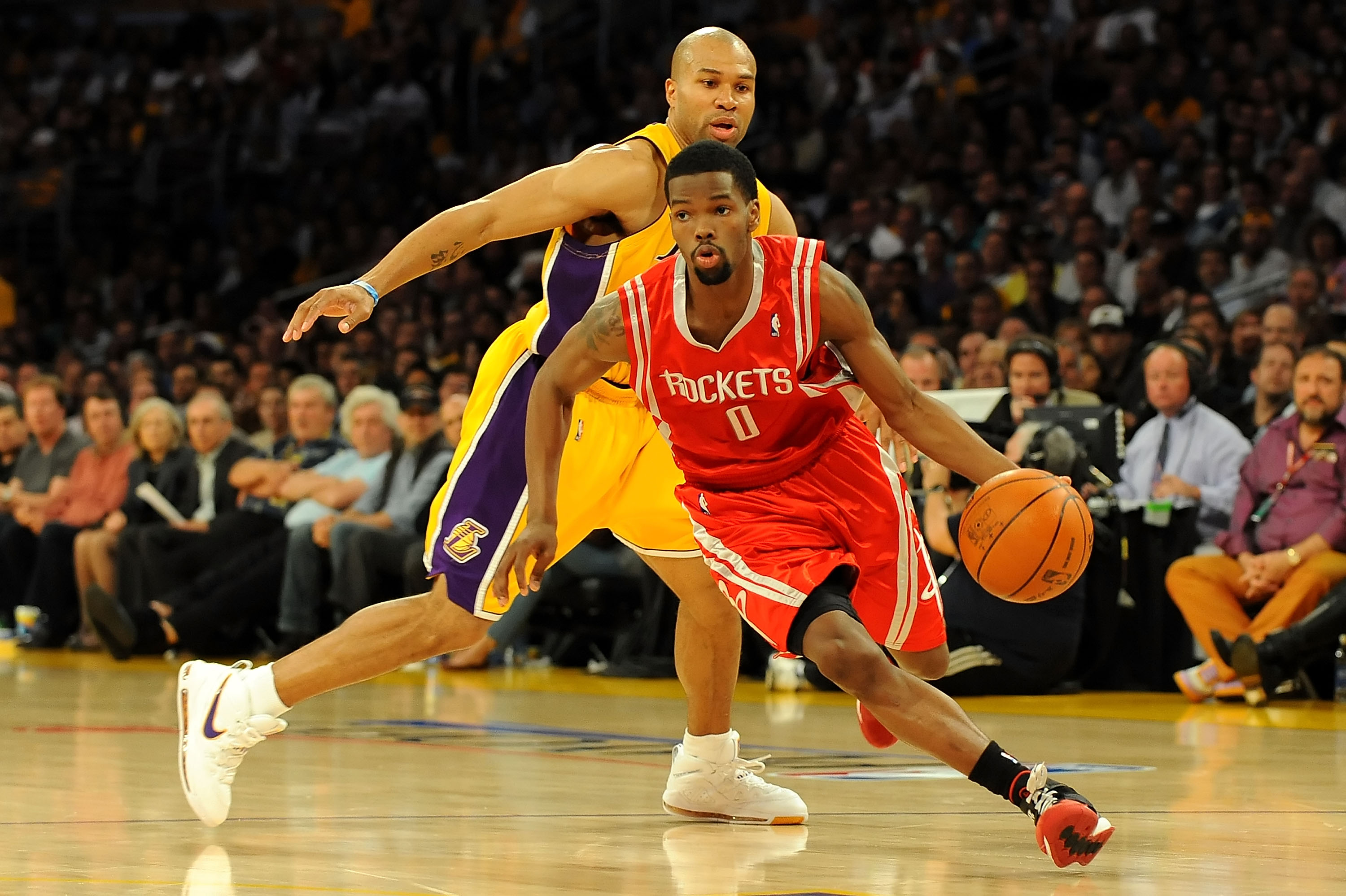 LOS ANGELES, CA - MAY 06:  Aaron Brooks #0 of the Houston Rockets moves the ball in front of Derek Fisher #2 of the Los Angeles Lakers in Game Two of the Western Conference Semifinals during the 2009 NBA Playoffs at Staples Center on May 6, 2009 in Los An