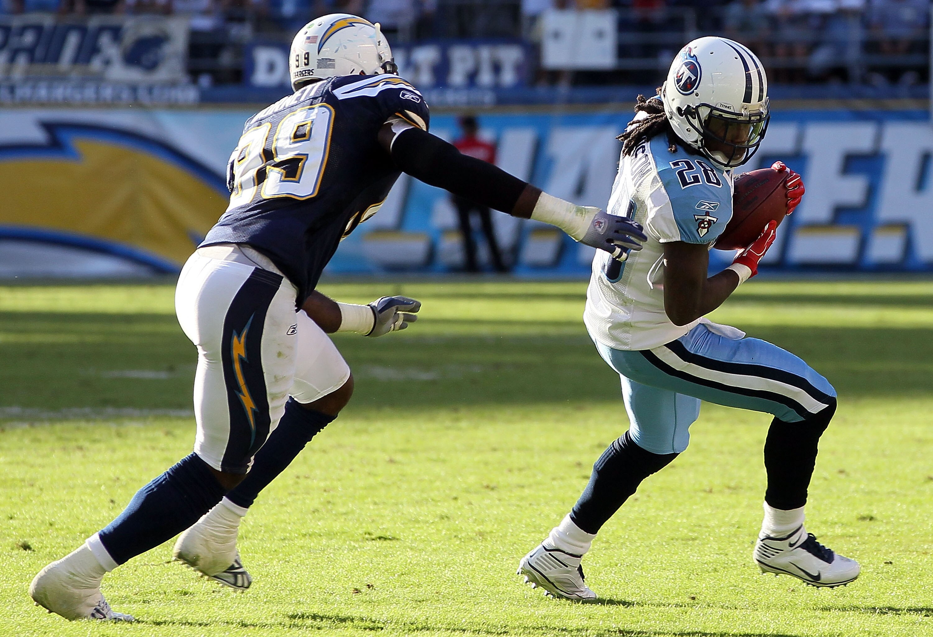 SAN DIEGO - OCTOBER 31:  Chris Johnson #28 of the Tennessee Titans is pursued by Seyi Ajirotutu #89 of the San Diego Chargers in the game at Qualcomm Stadium on October 31, 2010 in San Diego, California. The Chargers defeated the Titans 33-25.  (Photo by