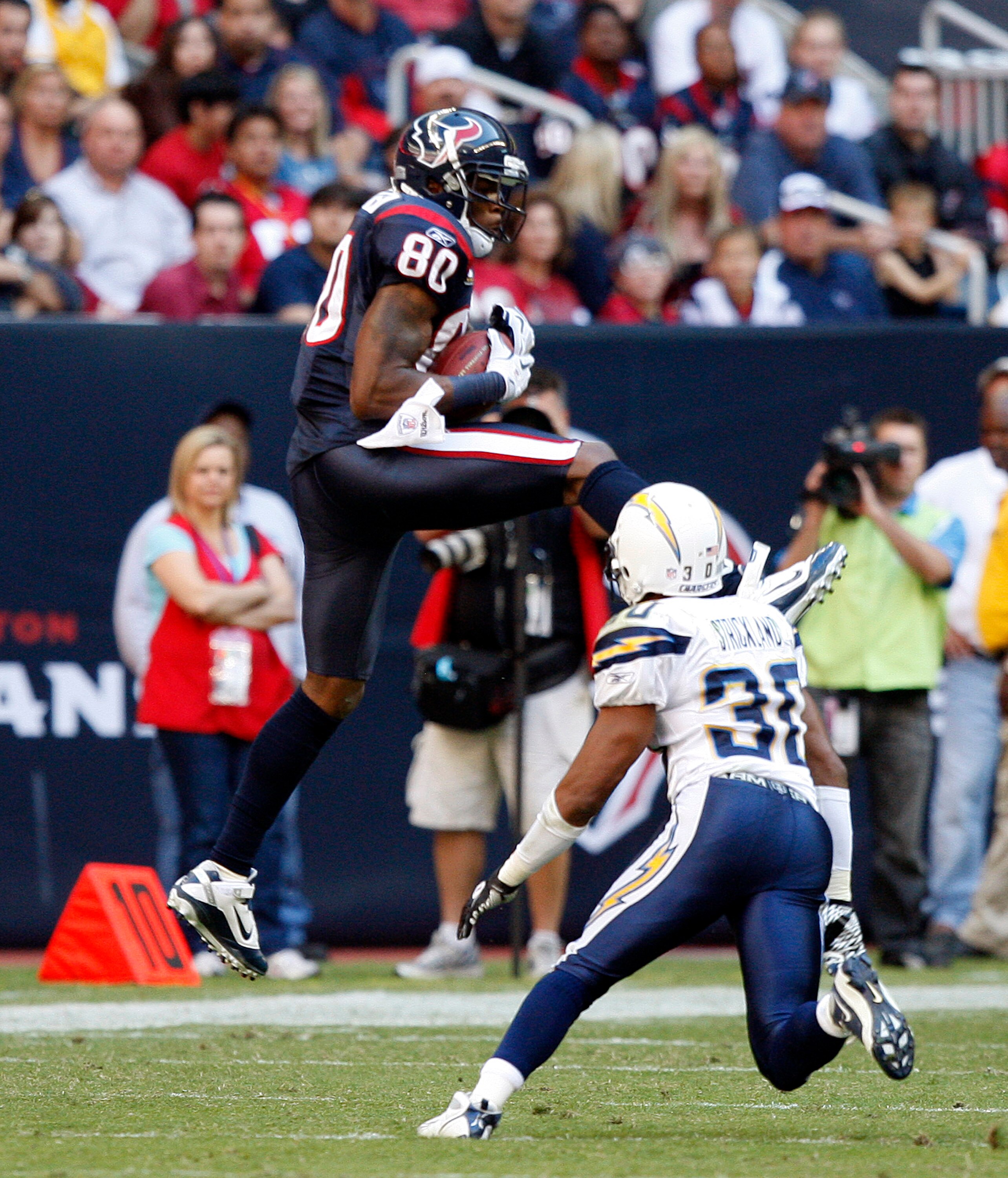 HOUSTON - NOVEMBER 07:  Wide receiver Andre Johnson #80 of the Houston Texans completes a pass in front of  cornerback Donald Strickland #30 of the San Diego Chargers at Reliant Stadium on November 7, 2010 in Houston, Texas.  (Photo by Bob Levey/Getty Ima
