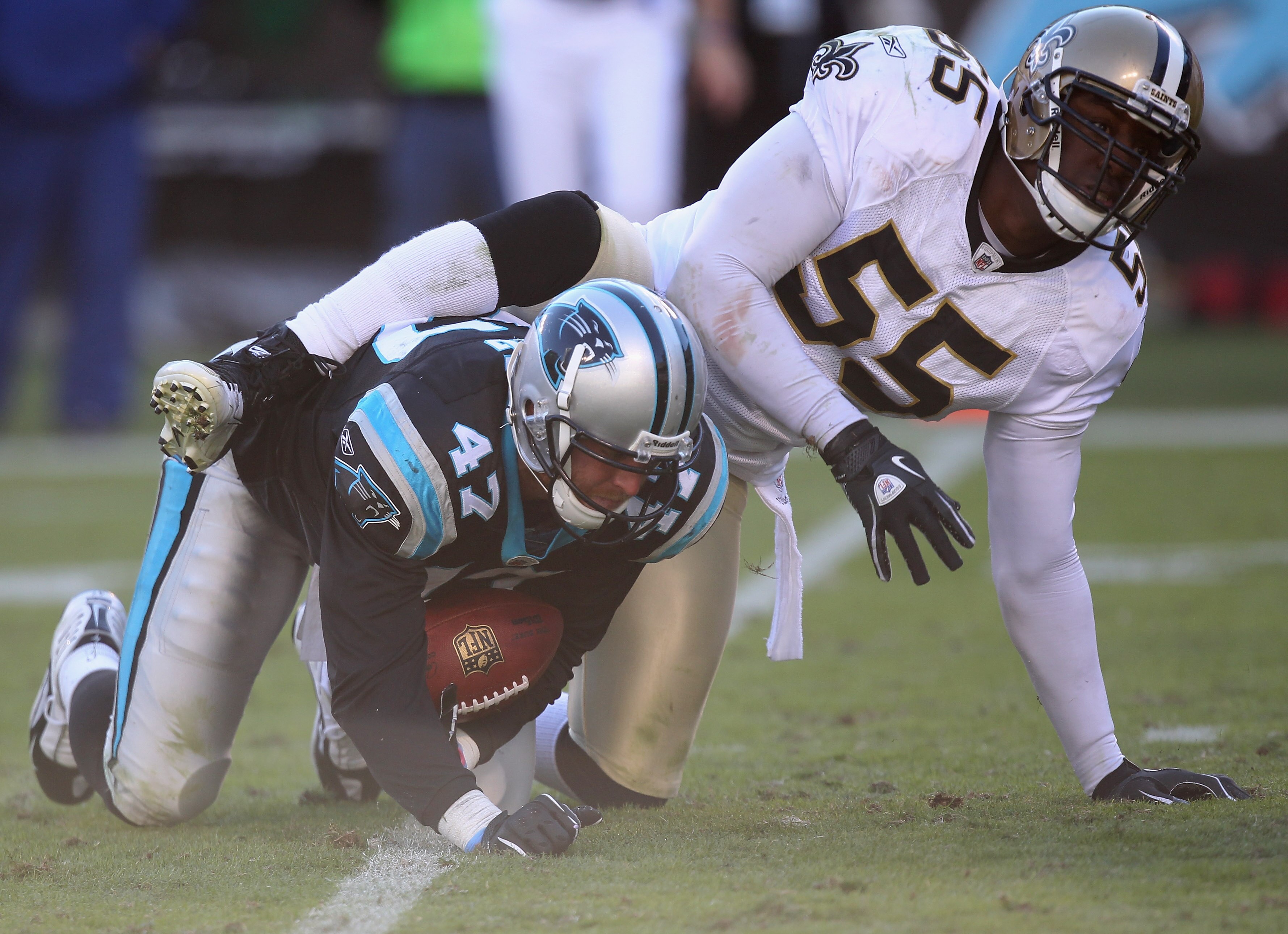 CHARLOTTE, NC - NOVEMBER 07:  Danny Clark #55 of the New Orleans Saints tackles Jeff King #47 of the Carolina Panthers during their game at Bank of America Stadium on November 7, 2010 in Charlotte, North Carolina.  (Photo by Streeter Lecka/Getty Images)