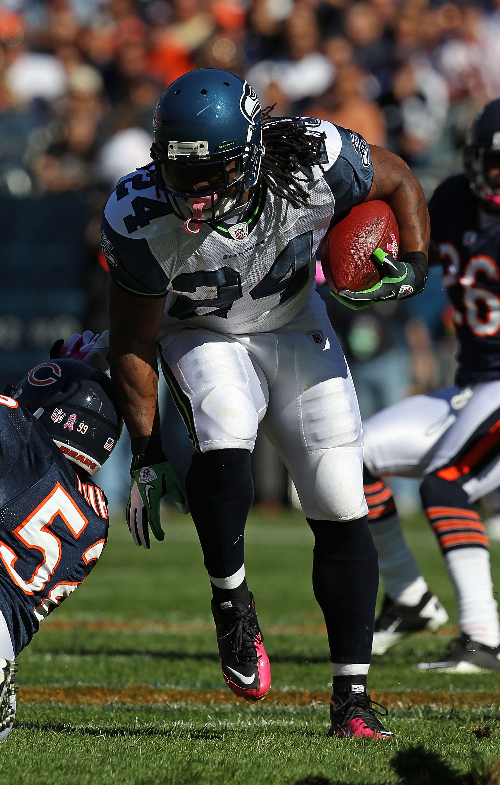 CHICAGO - OCTOBER 17: Marshawn Lynch #24 of the Seattle Seahawks runs past Brian Iwuh #52 of the Chicago Bears at Soldier Field on October 17, 2010 in Chicago, Illinois. The Seahawks defeated the Bears 23-20. (Photo by Jonathan Daniel/Getty Images)