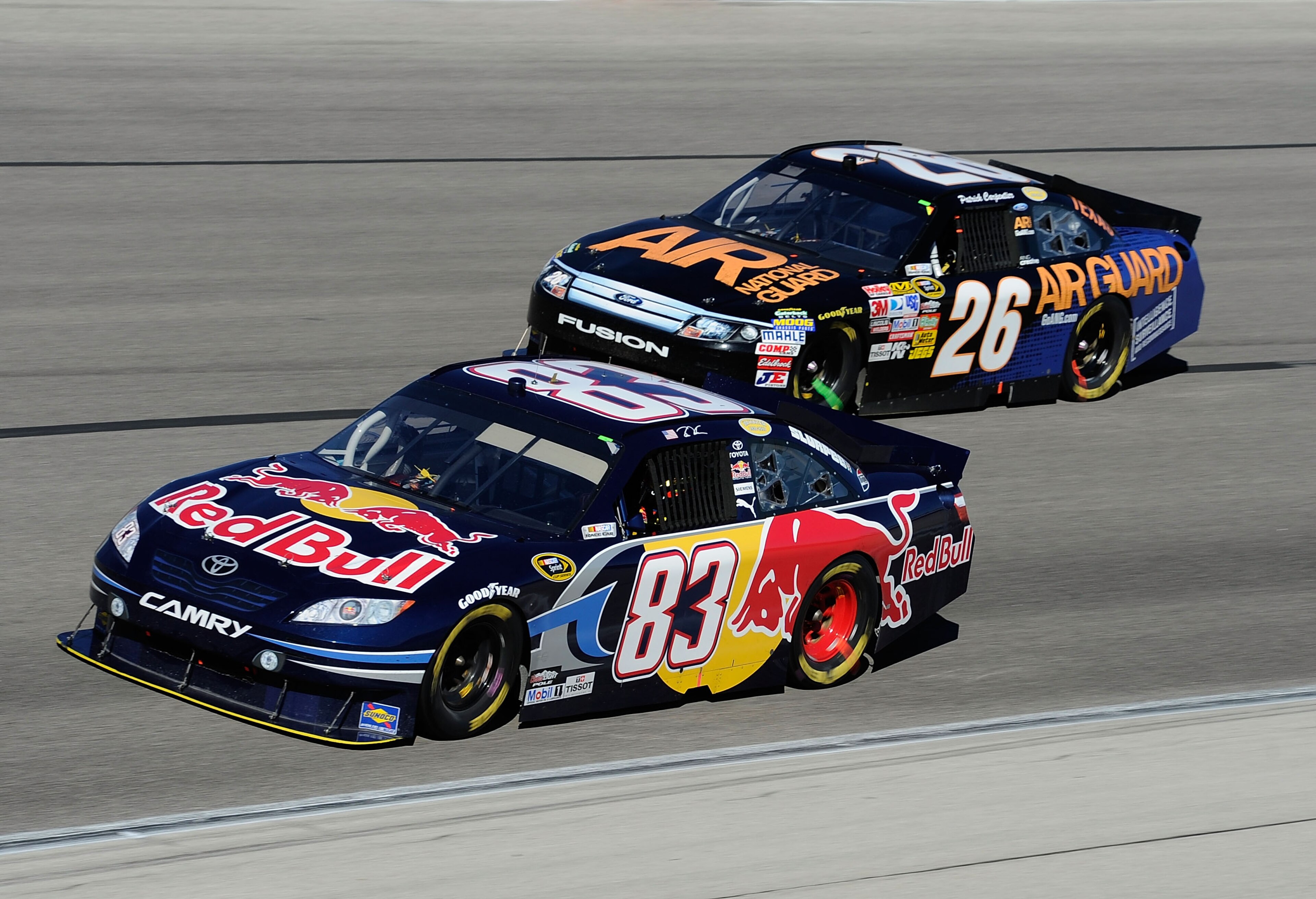 FORT WORTH, TX - NOVEMBER 07:  Kasey Kahne, driver of the #83 Red Bull Toyota, races Patrick Carpentier, driver of the #26 Air Guard Ford, during the NASCAR Sprint Cup Series AAA Texas 500 at Texas Motor Speedway on November 7, 2010 in Fort Worth, Texas.