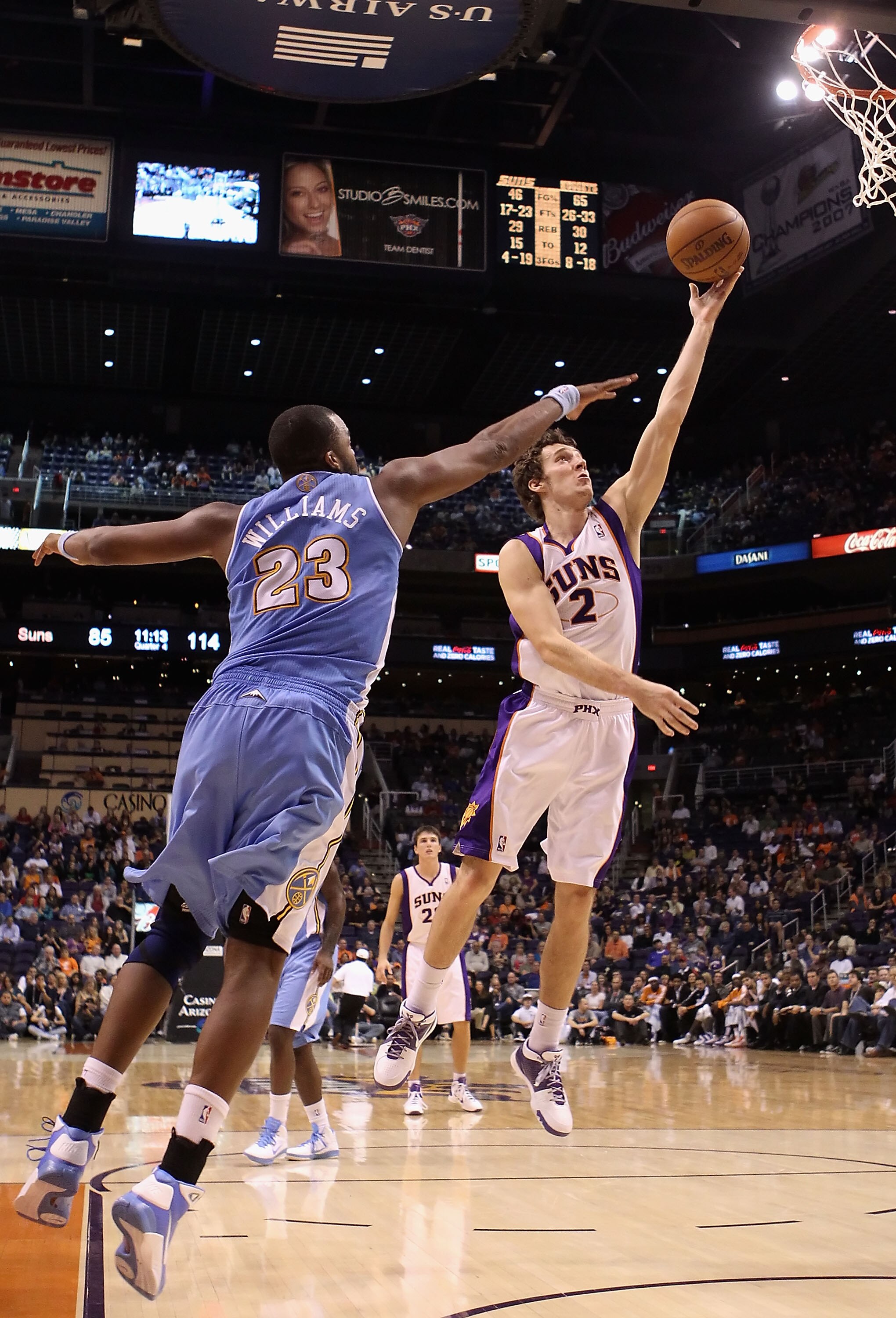 PHOENIX - OCTOBER 22:  Goran Dragic #2 of the Phoenix Suns lays up a shot past Shelden Williams #23 of the Denver Nuggets during the preseason NBA game at US Airways Center on October 22, 2010 in Phoenix, Arizona. NOTE TO USER: User expressly acknowledges