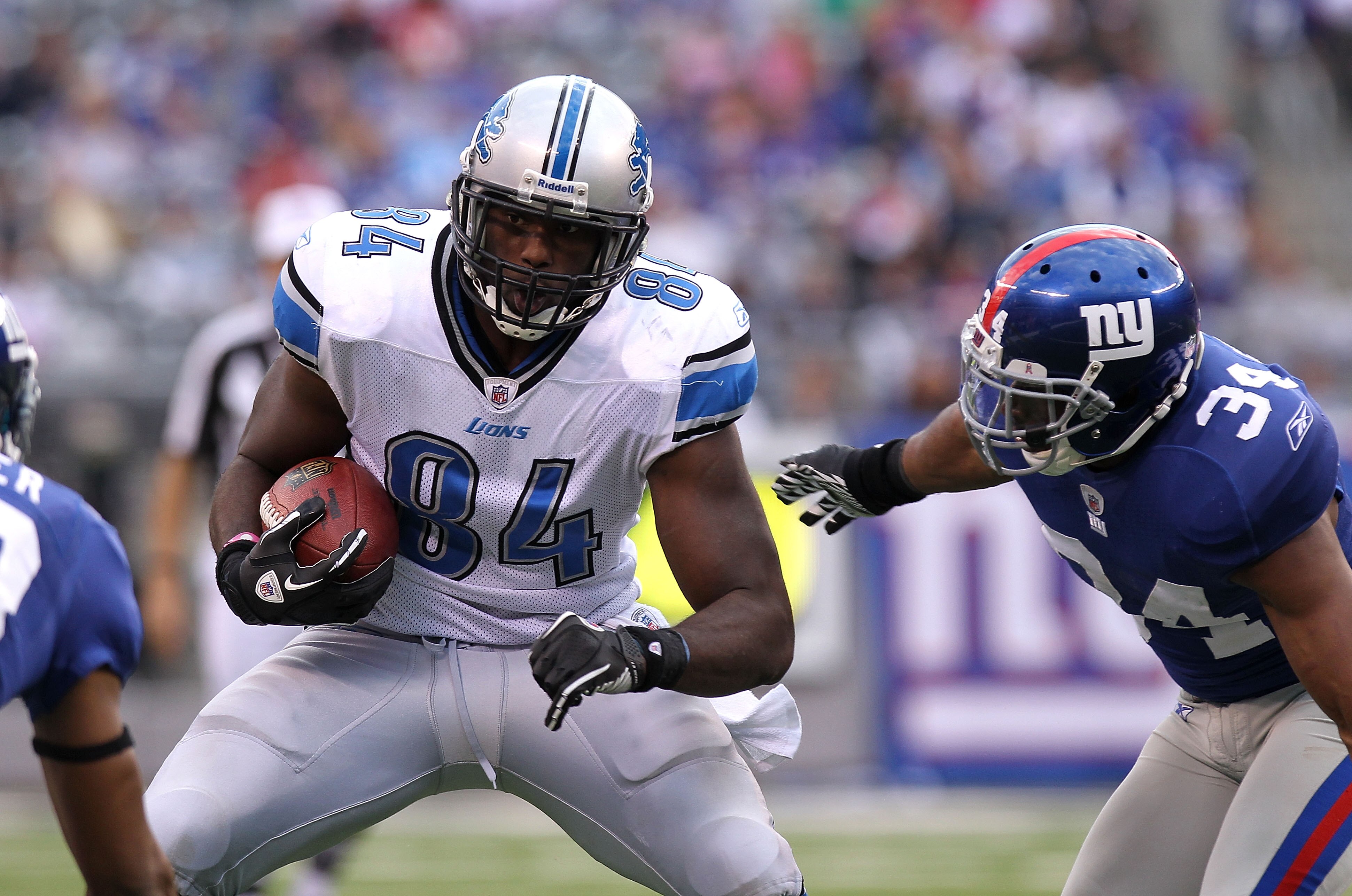 EAST RUTHERFORD, NJ - OCTOBER 17: Brandon Pettigrew #84 of the Detroit Lions runs with the ball under pressure from Deon Grant #34 of the New York Giants at New Meadowlands Stadium on October 17, 2010 in East Rutherford, New Jersey.  (Photo by Nick Laham/