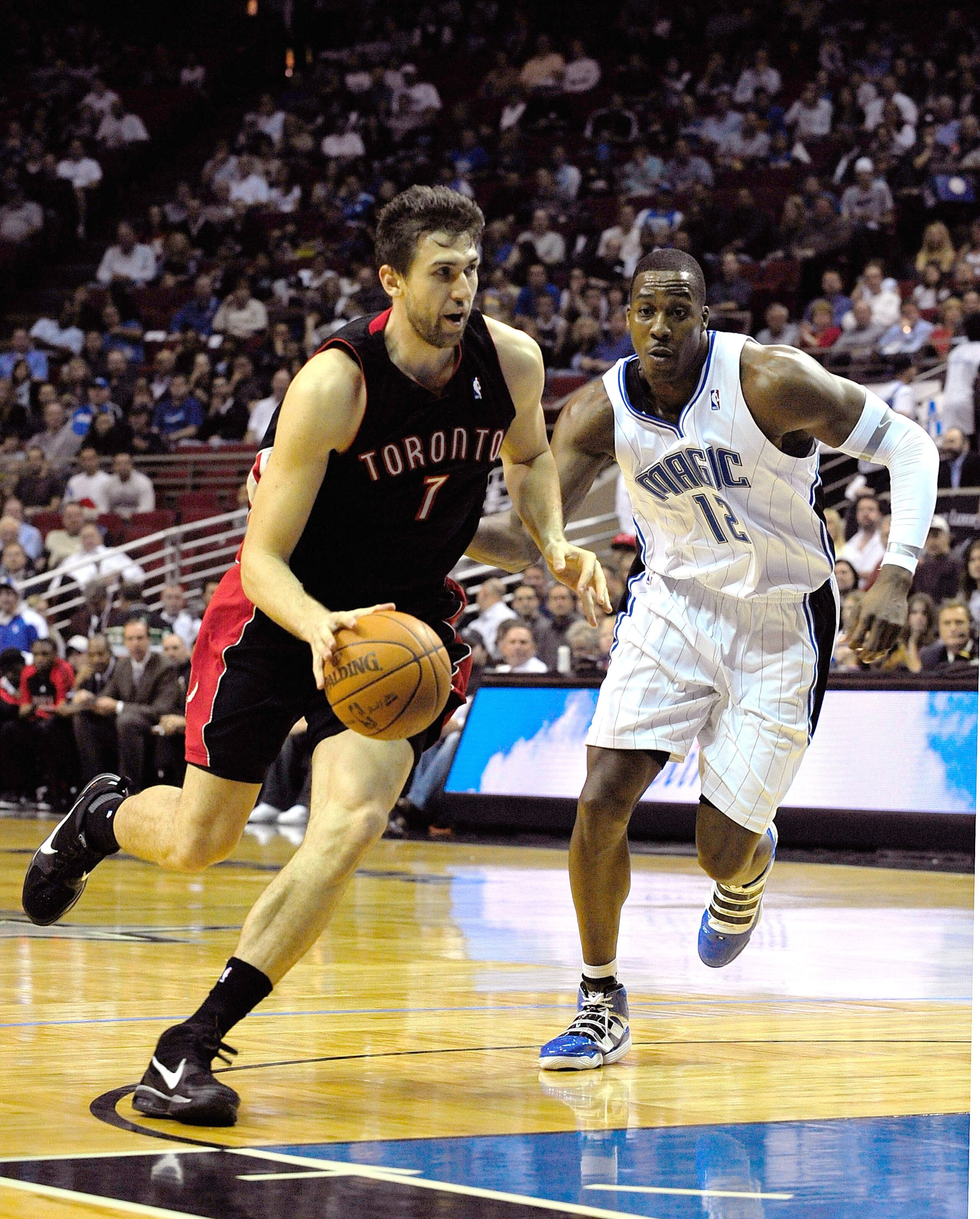 ORLANDO, FL - DECEMBER 16: Andrea Bargnani #7 of the Toronto Raptors drives past Dwight Howard #12 of the Orlando Magic during the game at Amway Arena on December 16, 2009 in Orlando, Florida. NOTE TO USER: User expressly acknowledges and agrees that, b ORLANDO, FL - DECEMBER 16: Andrea Bargnani #7 of the Toronto Raptors drives past Dwight Howard #12 of the Orlando Magic during the game at Amway Arena on December 16, 2009 in Orlando, Florida. NOTE TO USER: User expressly acknowledges and agrees that, b