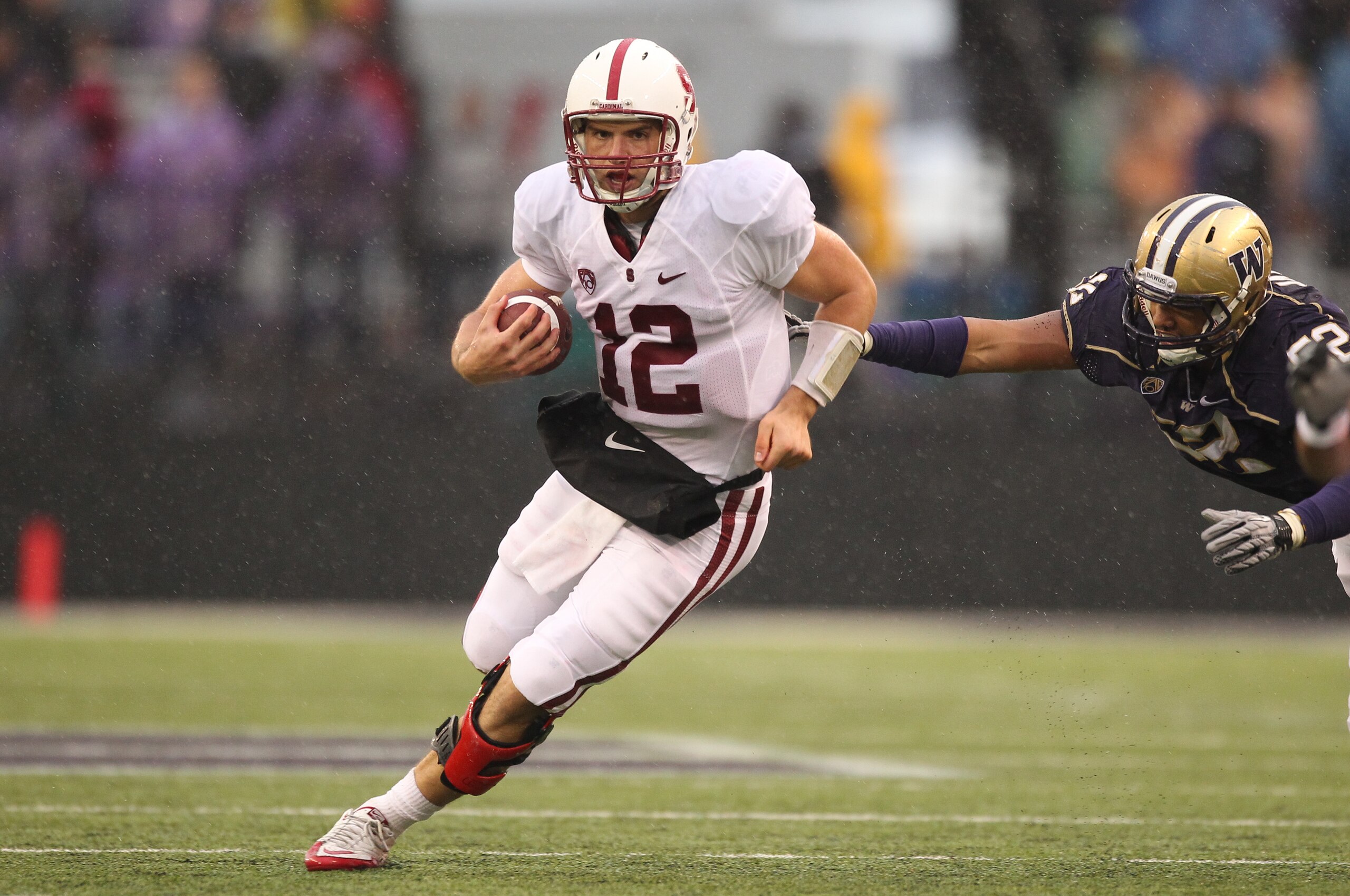SEATTLE - OCTOBER 30:  Quarterback Andrew Luck #12 of the Stanford Cardinal rushes against Hau'oli Jamora #52 of the Washington Huskies on October 30, 2010 at Husky Stadium in Seattle, Washington. Stanford won 41-0. (Photo by Otto Greule Jr/Getty Images)