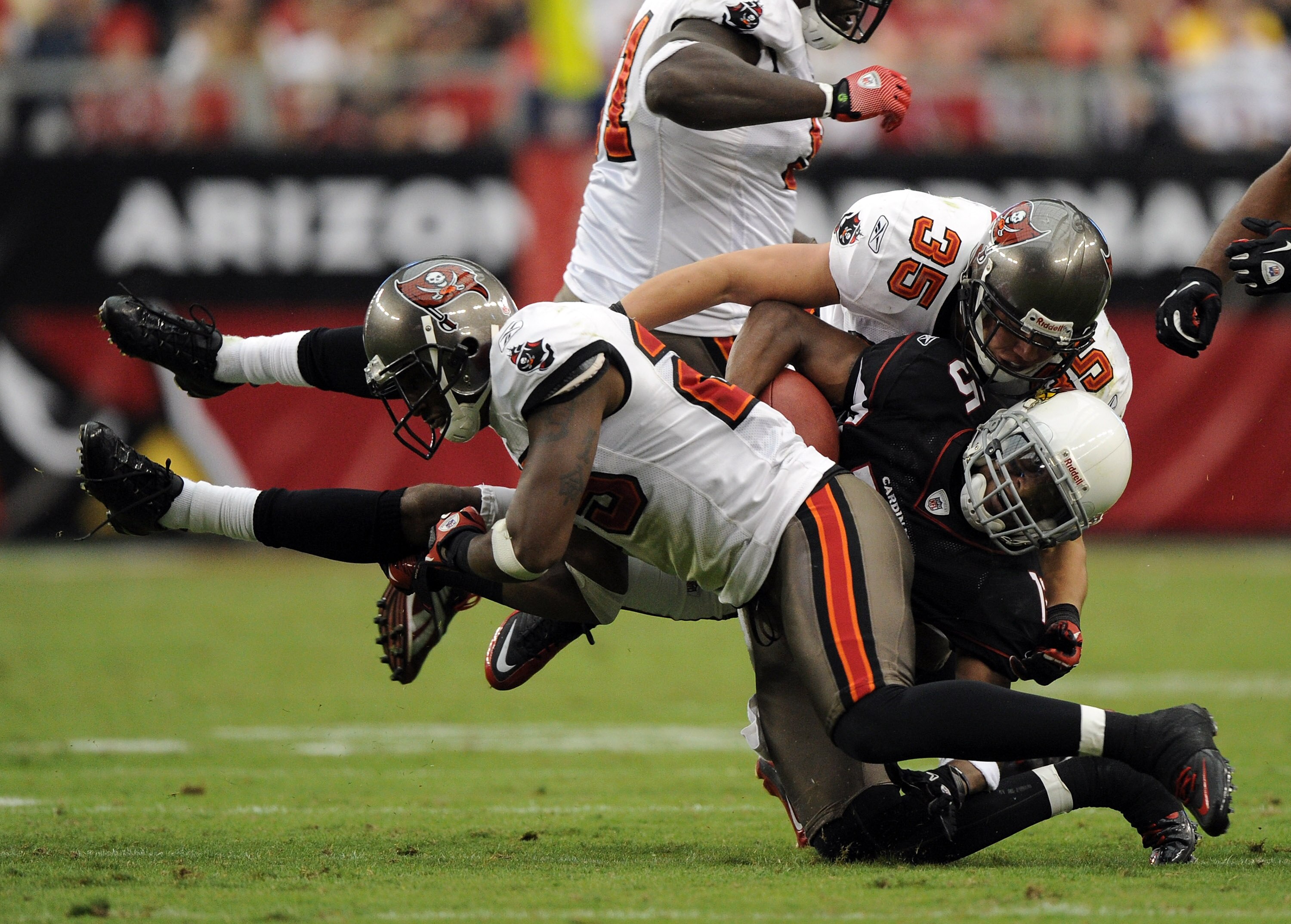 GLENDALE, AZ - OCTOBER 31:  Steve Breaston #15 of the Arizona Cardinals is hit by Aqib Talib #25 and Cody Grimm #35 of the Tampa Bay Buccaneers at University of Phoenix Stadium on October 31, 2010 in Glendale, Arizona.  (Photo by Harry How/Getty Images)