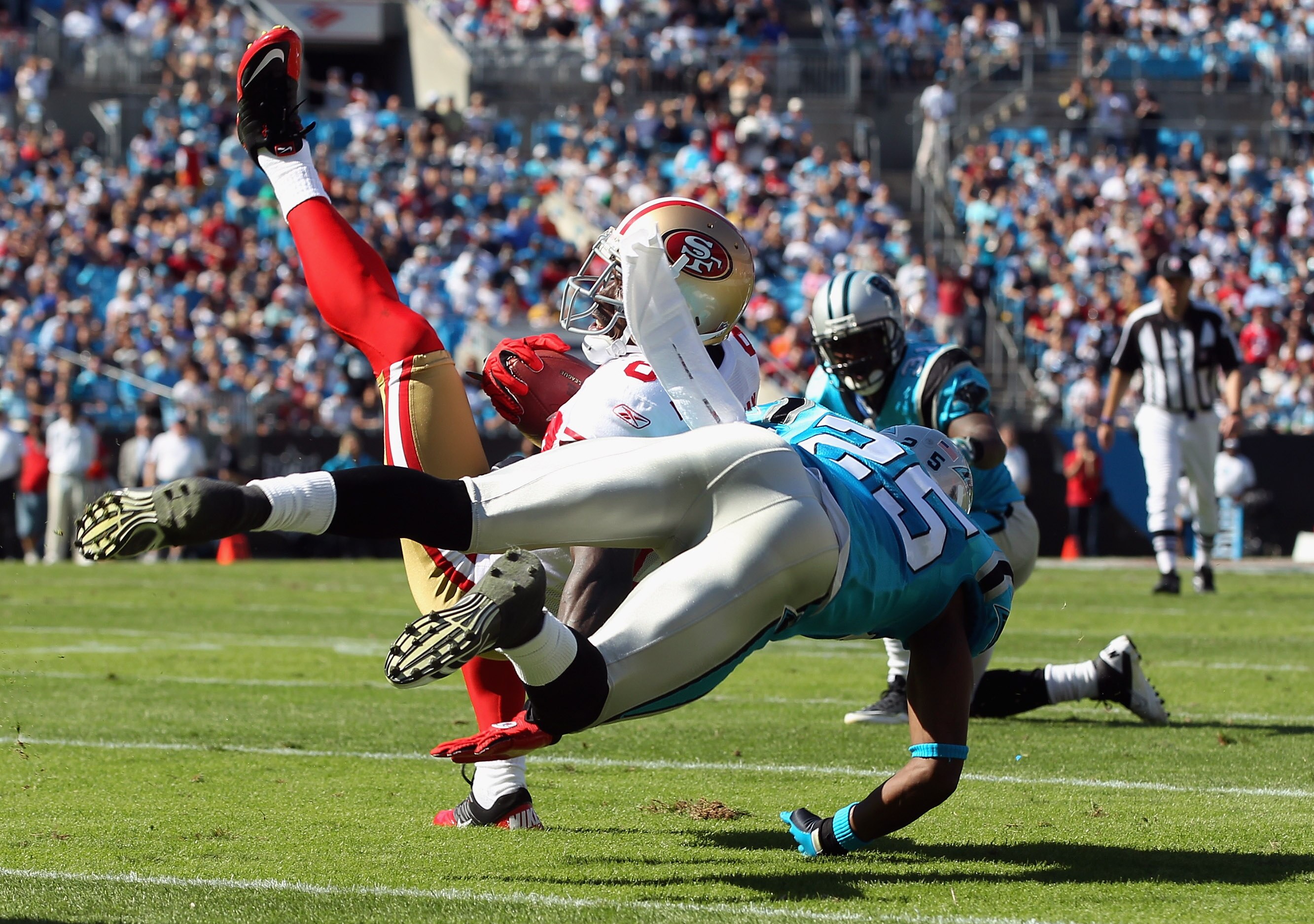 CHARLOTTE, NC - OCTOBER 24:  Josh Morgan #84 of the San Francisco 49ers is tackled by Marcus Hudson #25 of the Carolina Panthers during their game at Bank of America Stadium on October 24, 2010 in Charlotte, North Carolina.  (Photo by Streeter Lecka/Getty