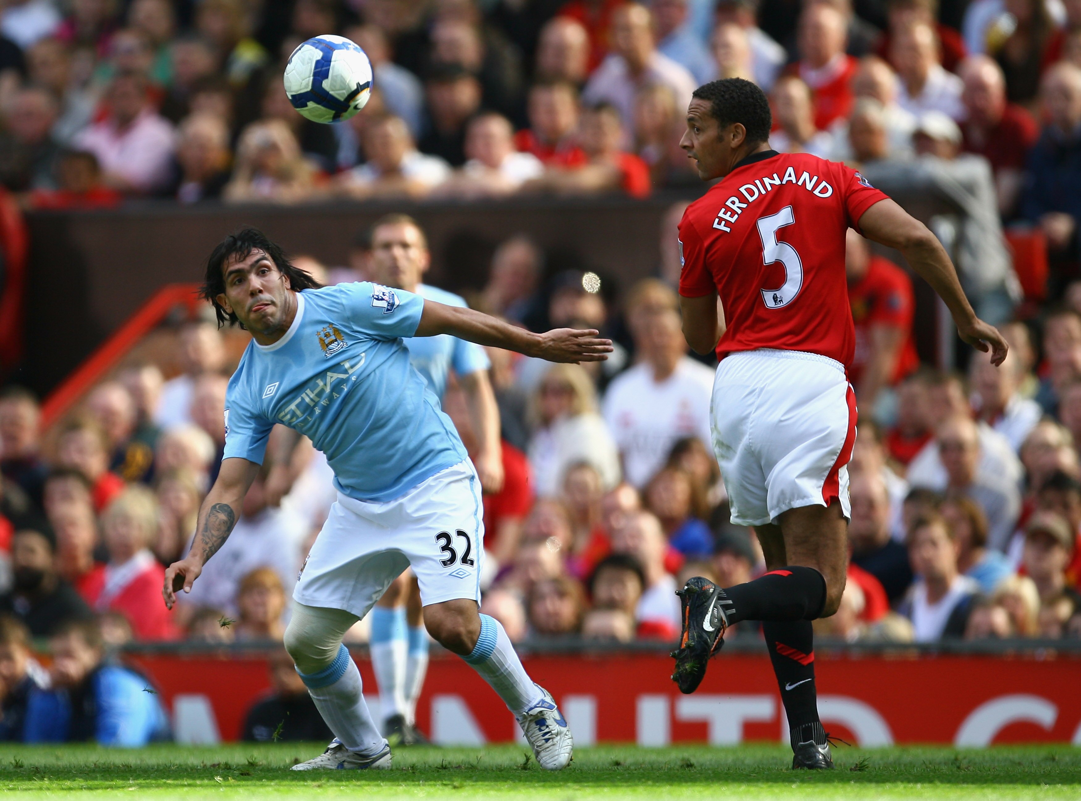 MANCHESTER, ENGLAND - SEPTEMBER 20:  Carlos Tevez of Manchester City competes for the ball with Rio Ferdinand of Manchester United during the Barclays Premier League match between Manchester United and Manchester City at Old Trafford on September 20, 2009