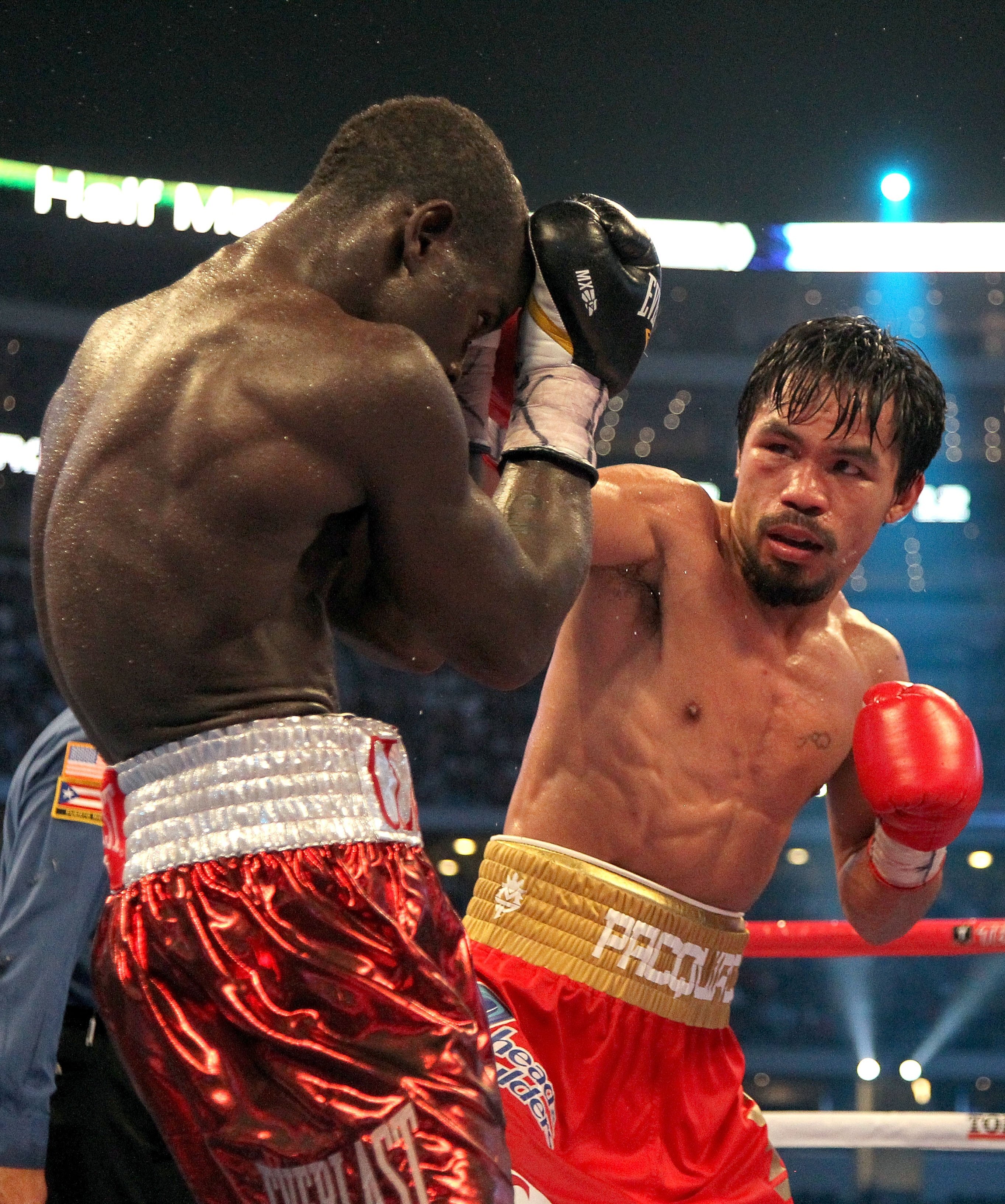 ARLINGTON, TX - MARCH 13:  (R-L) Manny Pacquiao of the Philippines throws a right to the head of Joshua Clottey of Ghana during the WBO welterweight title fight at Cowboys Stadium on March 13, 2010 in Arlington, Texas. Pacquiao defeated Clottey by unanimo