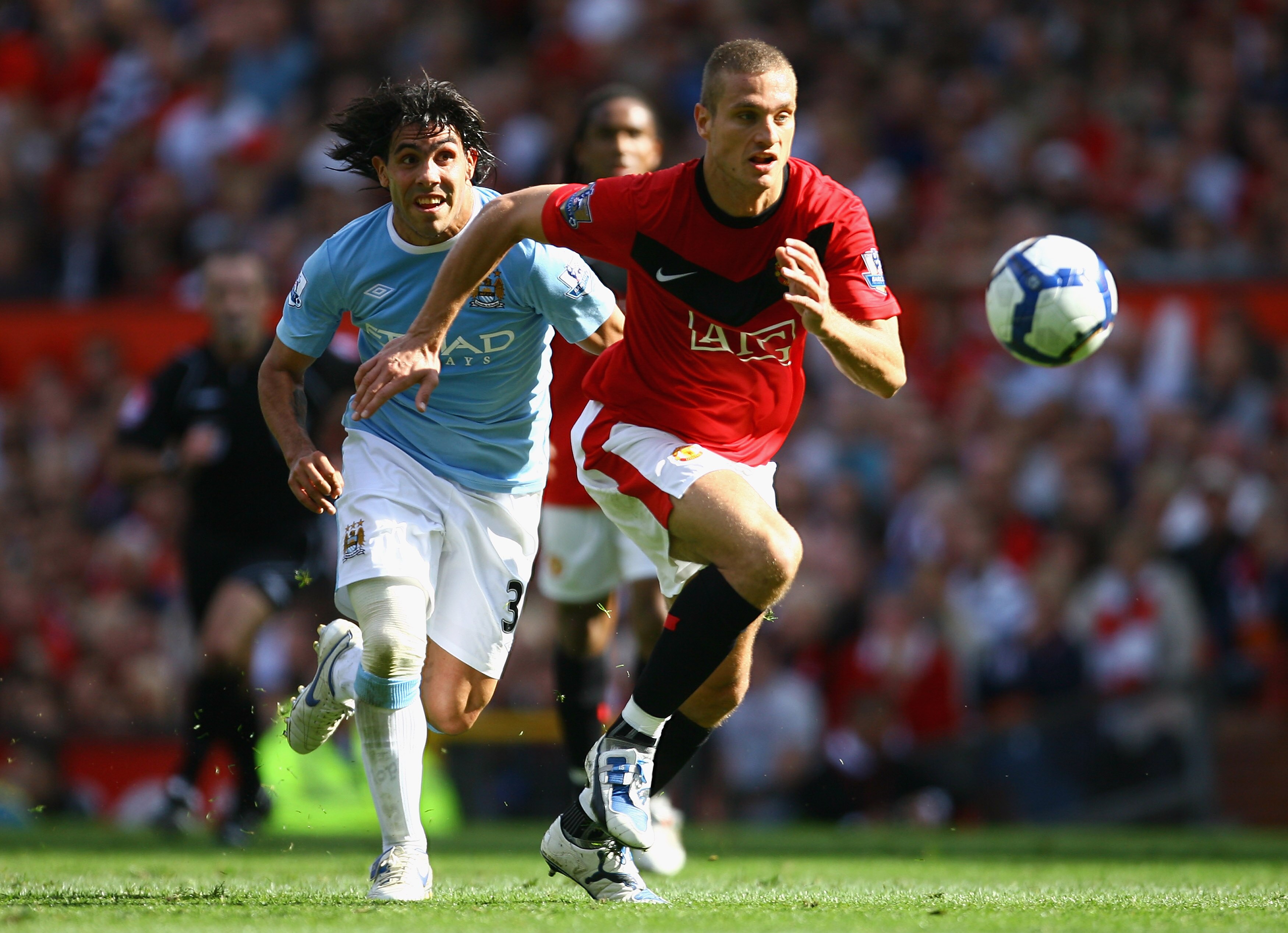 MANCHESTER, ENGLAND - SEPTEMBER 20:   Nemanja Vidic of Manchester United is pursued by Carlos Tevez of Manchester City during the Barclays Premier League match between Manchester United and Manchester City at Old Trafford on September 20, 2009 in Manchest