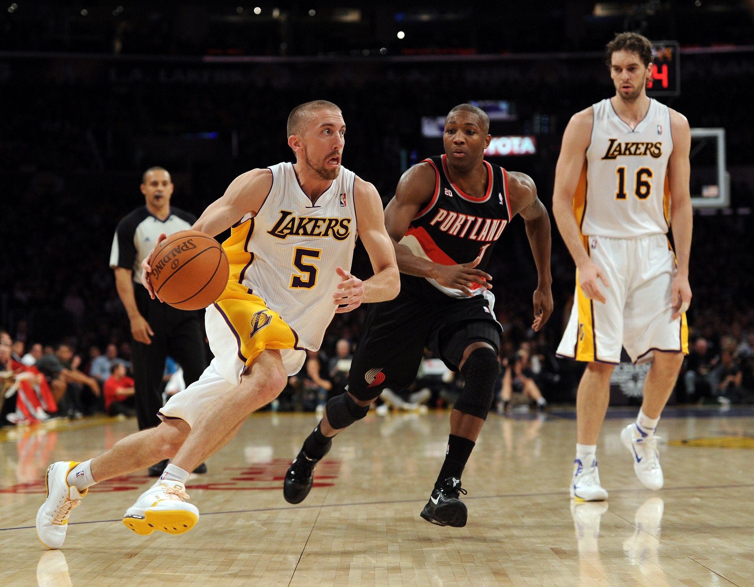 LOS ANGELES, CA - NOVEMBER 07:  Steve Blake #5 of the Los Angeles Lakers goes in for a layup past Armon Johnson #1 as Pau Gasol #16 looks on during the first half at the Staples Center on November 7, 2010 in Los Angeles, California.  NOTE TO USER: User ex