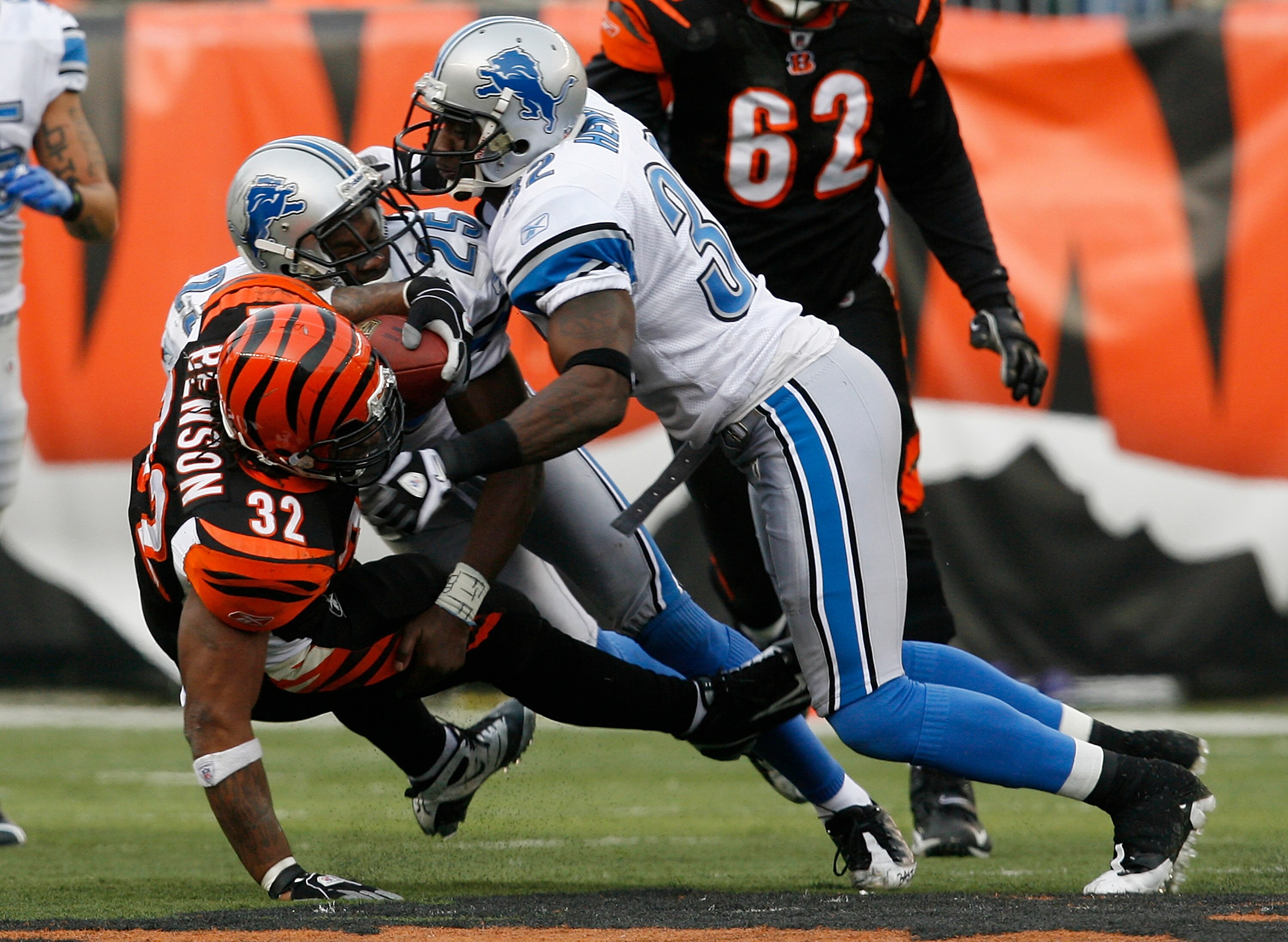CINCINNATI, OH - DECEMBER 6: Cedric Benson #32 of the Cincinnati Bengals is tackled by Anthony Henry #32 and Marvin White #25 of the Detroit Lions in their NFL game at Paul Brown Stadium December 6, 2009 in Cincinnati, Ohio.    (Photo by John Sommers II/G