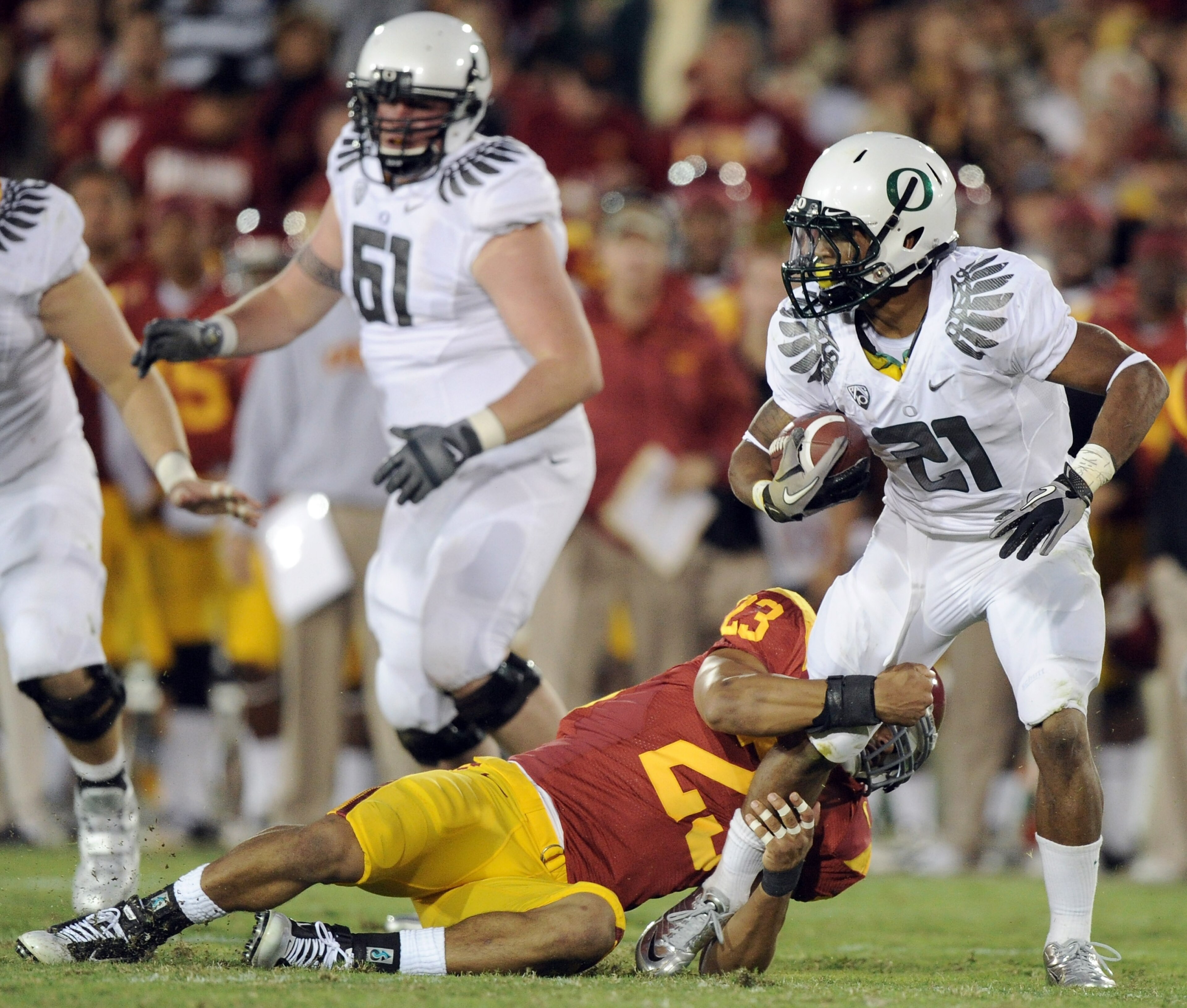 LOS ANGELES, CA - OCTOBER 30:  LaMichael James #21 of the Oregon Ducks is tackled for a loss by Shane Horton #23 of the USC Trojans during the second quarter at Los Angeles Memorial Coliseum on October 30, 2010 in Los Angeles, California.  (Photo by Harry