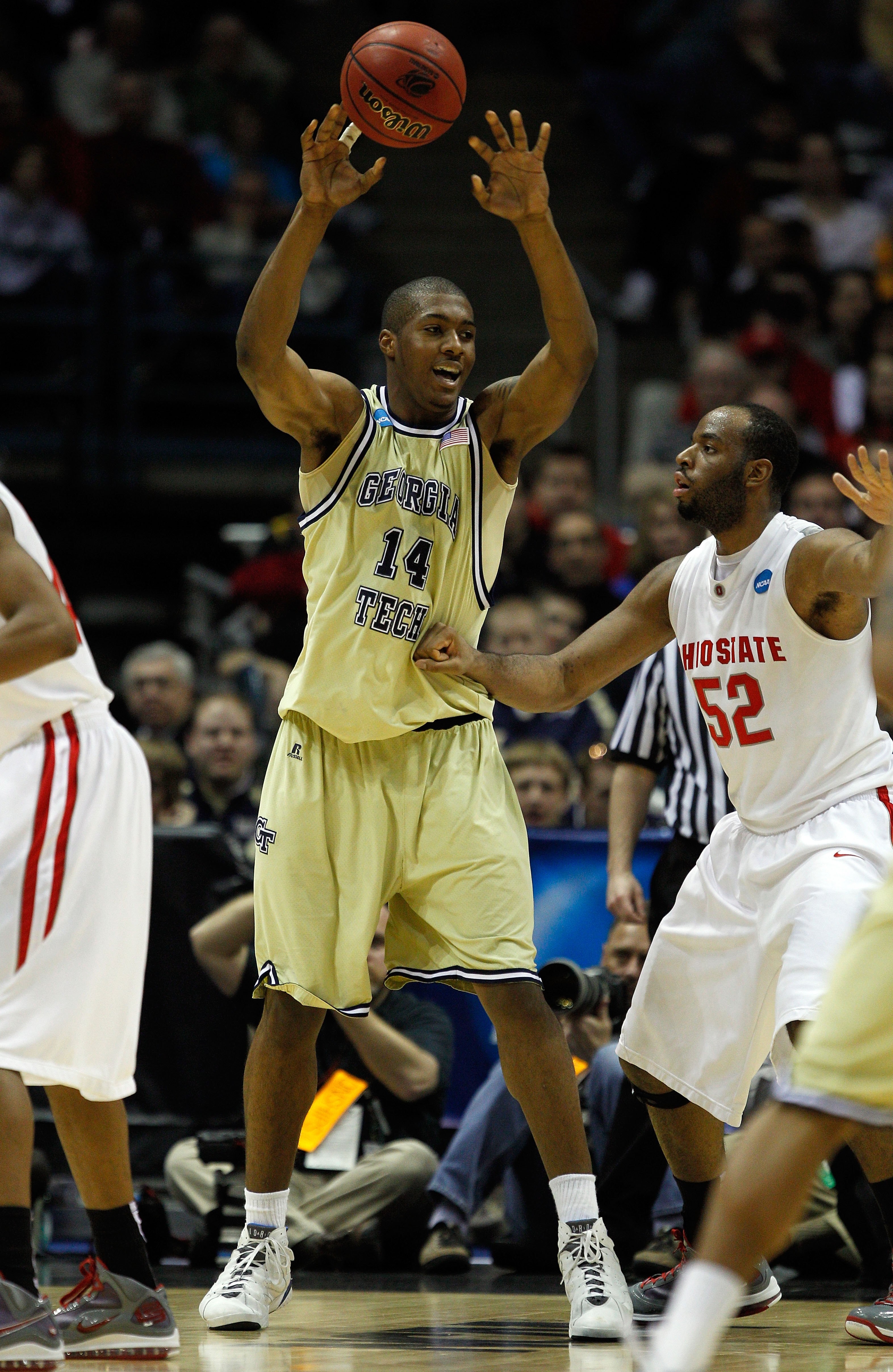 MILWAUKEE - MARCH 21:  Derrick Favors #14 of the Georgia Tech Yellow Jackets passes the ball as he is covered by Dallas Lauderdale #52 of the Ohio State Buckeyes during the second round of the 2010 NCAA men's basketball tournament at the Bradley Center on