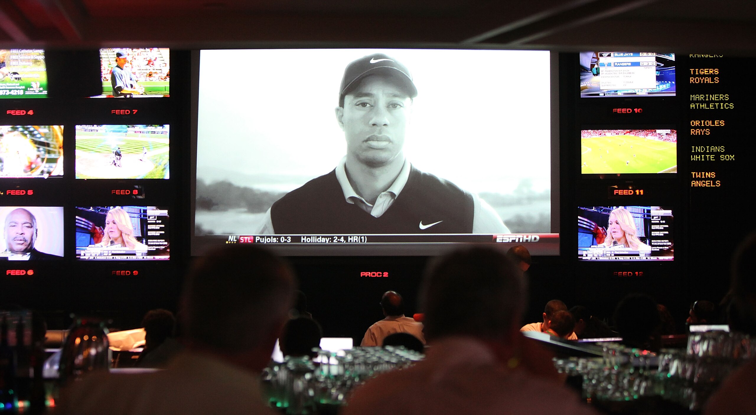 NEW YORK - APRIL 08: Sports fans watch the controversial new Tiger Woods Nike advertisement featuring the voice of his late father Earl during Masters coverage televised at ESPN Zone April 8, 2010 in New York City. Woods is playing in the Masters for his NEW YORK - APRIL 08: Sports fans watch the controversial new Tiger Woods Nike advertisement featuring the voice of his late father Earl during Masters coverage televised at ESPN Zone April 8, 2010 in New York City. Woods is playing in the Masters for his