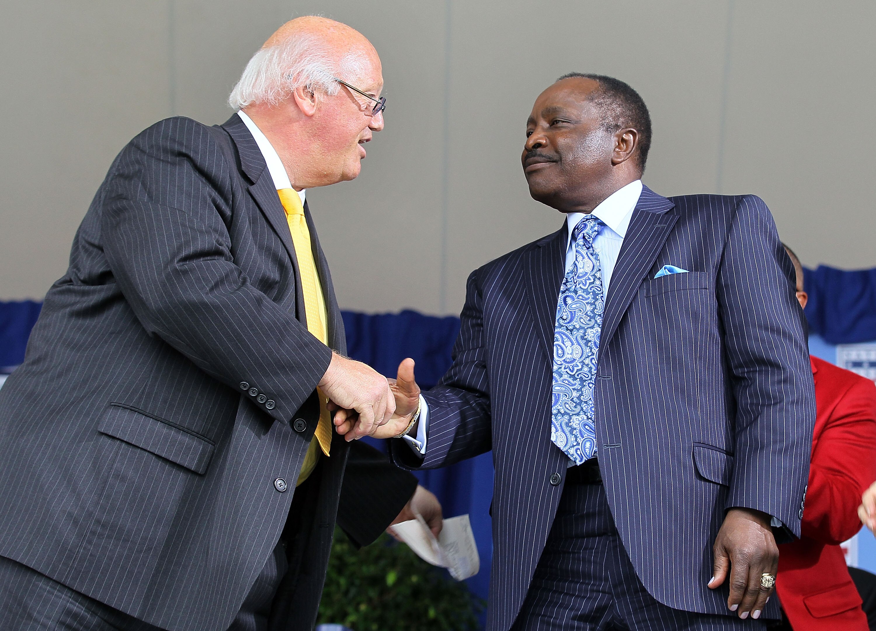COOPERSTOWN, NY - JULY 25:  Jon Miller (L) shakes hands with Hall of Famer Joe Morgan after Miller received the Ford C. Frick award for contributions in baseball broadcasting at Clark Sports Center during the Baseball Hall of Fame induction ceremony on Ju