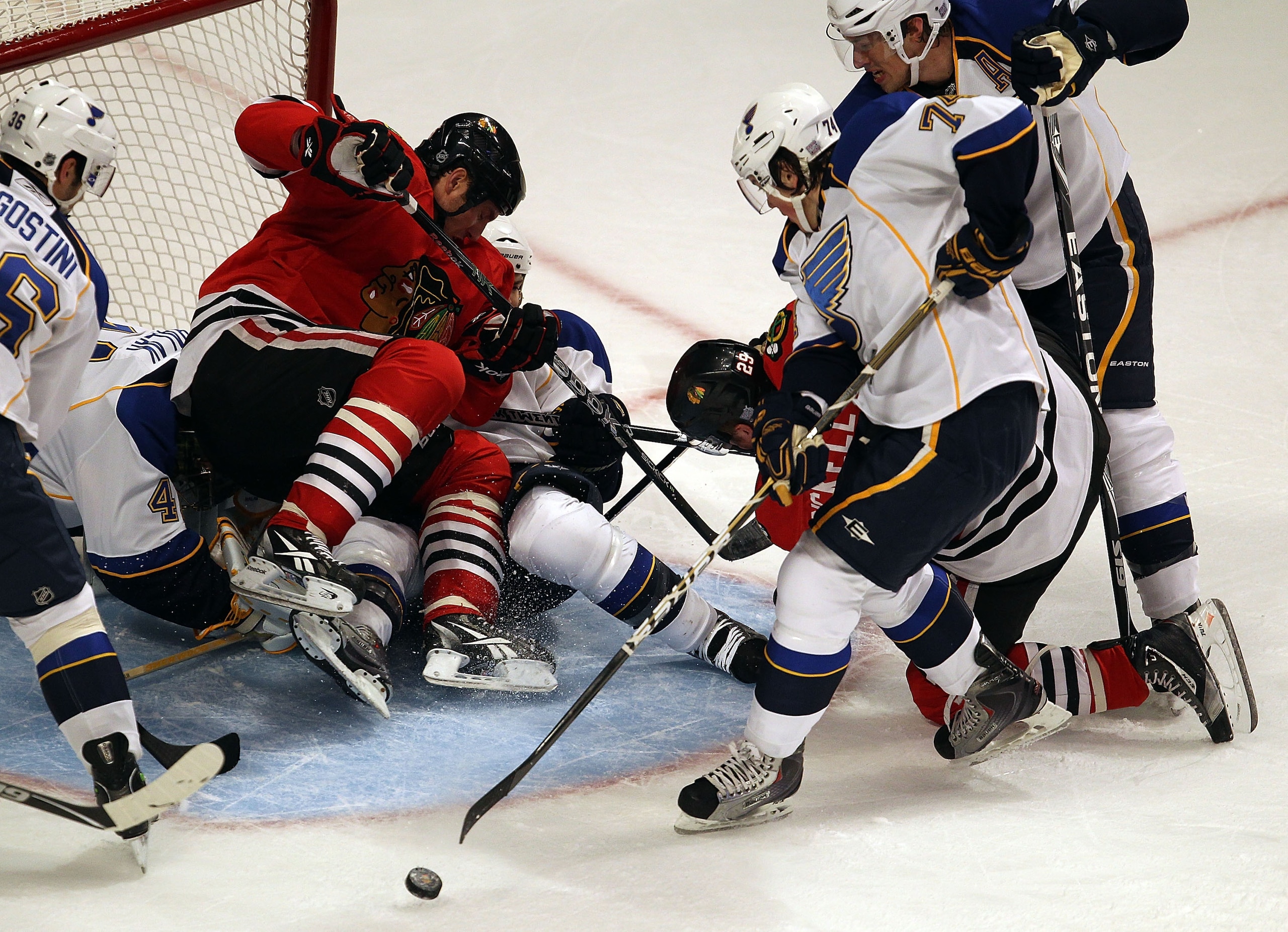 CHICAGO - OCTOBER 18: Fernando Pisani #15 of the Chicago Blackhawks falls on Jaroslav Halak #41 and Carlo Colaiacovo #28 of the St. Louis Blues as teammate Bryan Bickell #29 tries to shoot under pressure from T.J. Oshie #74 and Erik Johnson #6 at the Unit
