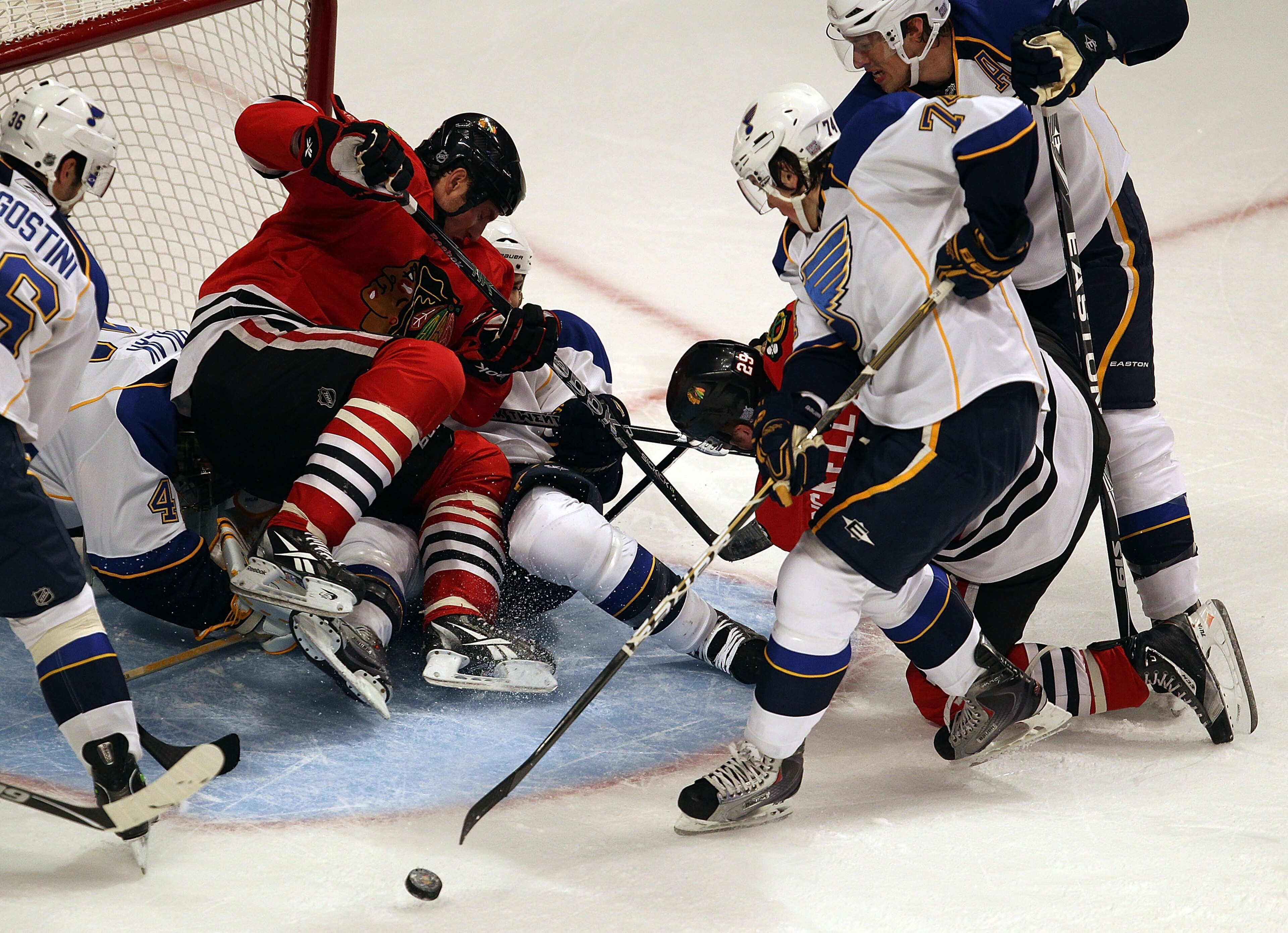 CHICAGO - OCTOBER 18: Fernando Pisani #15 of the Chicago Blackhawks falls on Jaroslav Halak #41 and Carlo Colaiacovo #28 of the St. Louis Blues as teammate Bryan Bickell #29 tries to shoot under pressure from T.J. Oshie #74 and Erik Johnson #6 at the Unit