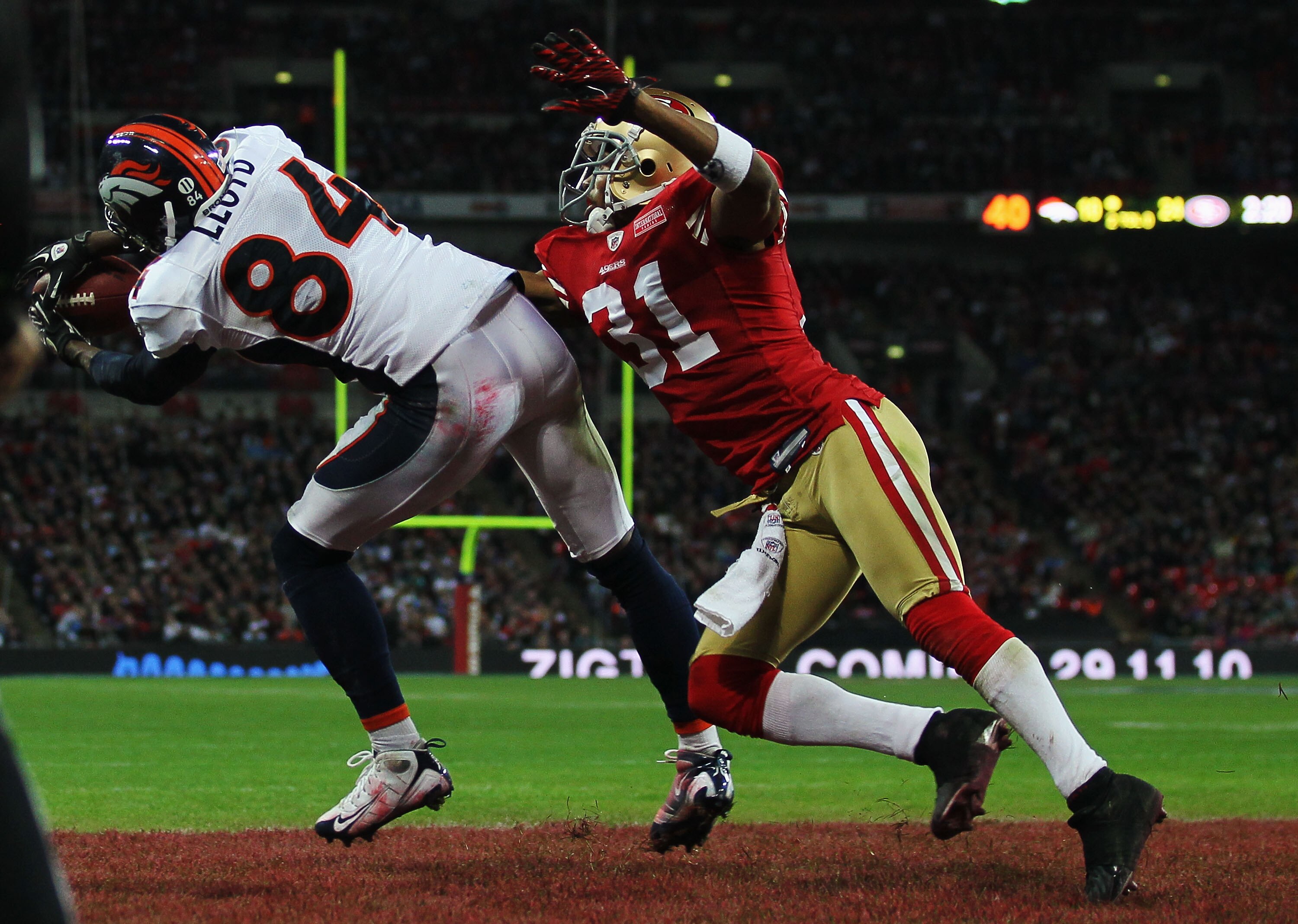 LONDON, ENGLAND - OCTOBER 31:  Brandon Lloyd #84 of Denver Broncos beats William James #31 of San Francisco 49ers to the ball as he scores their second touchdown during the NFL International Series match between Denver Broncos and San Francisco 49ers at W