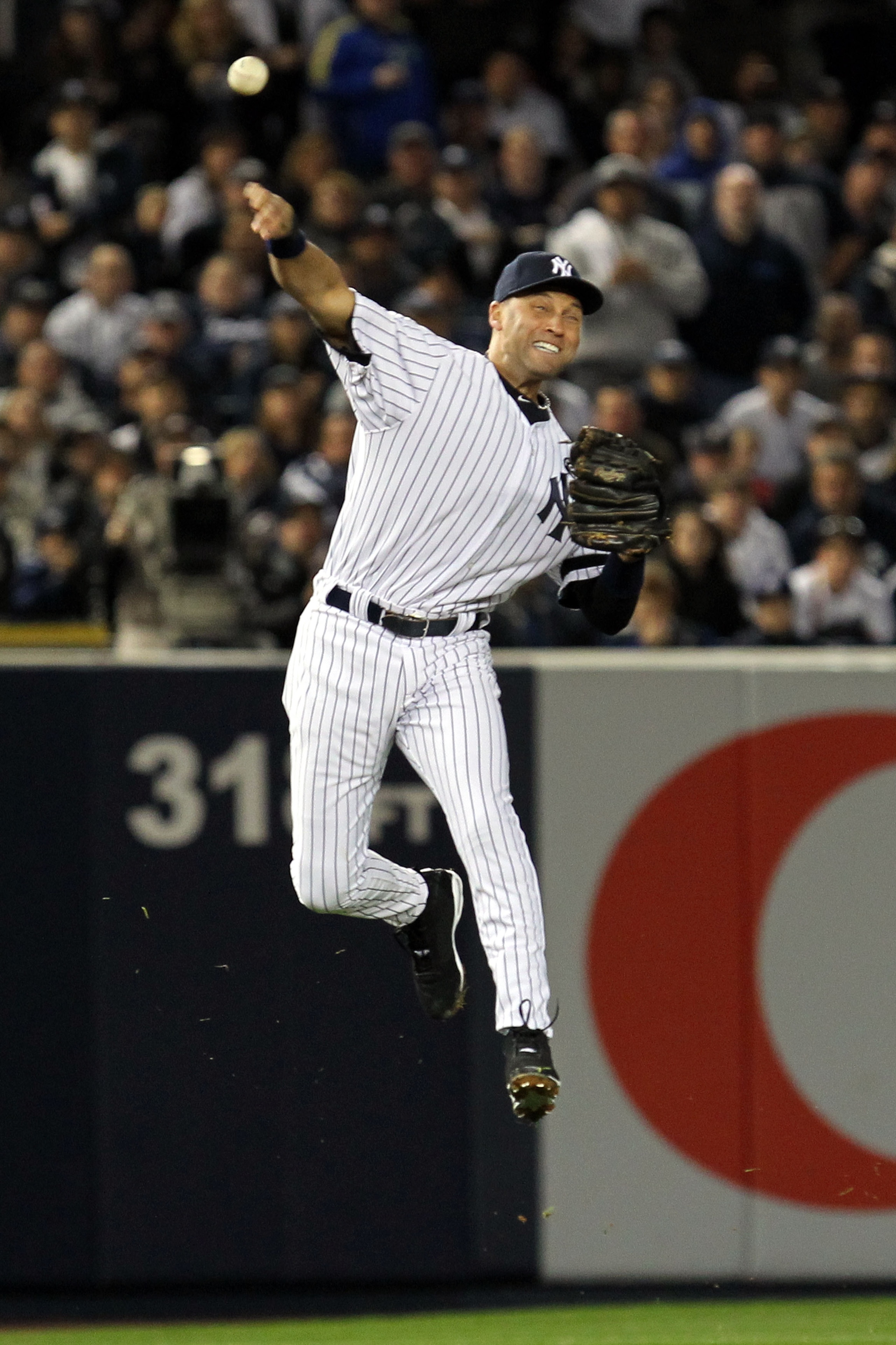 NEW YORK - OCTOBER 18:  Derek Jeter #2 of the New York Yankees fails on a attempt to throw out Michael Young #10 of the Texas Rangers on an infield single in the top of the third inning of Game Three of the ALCS during the 2010 MLB Playoffs at Yankee Stad