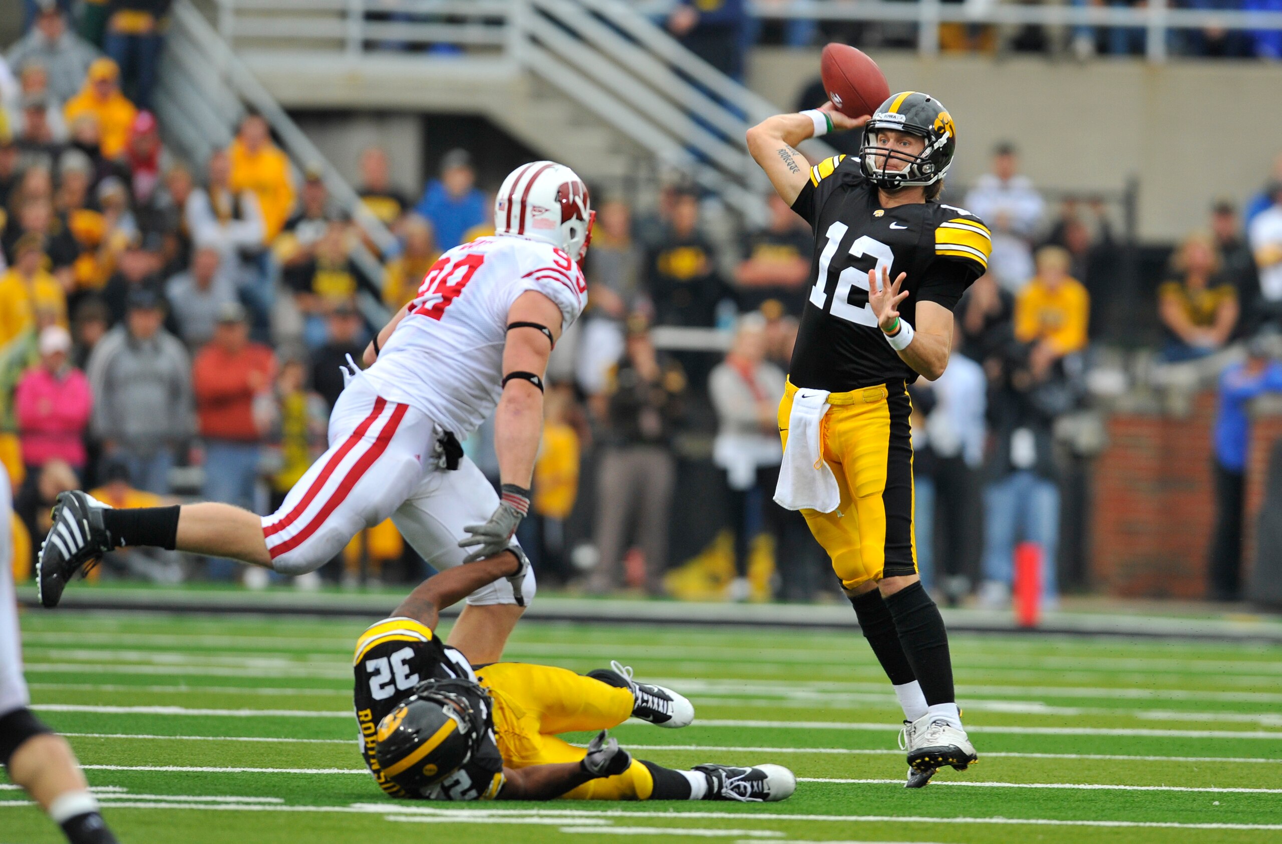 IOWA CITY, IA - OCTOBER 23- Quarterback Ricky Stanzi #12 of the University of Iowa Hawkeyes throws under pressure from defensive lineman J.J. Watt #99 of the Wisconsin Badgers during the second half of play at Kinnick Stadium on October 23, 2010 in Iowa C