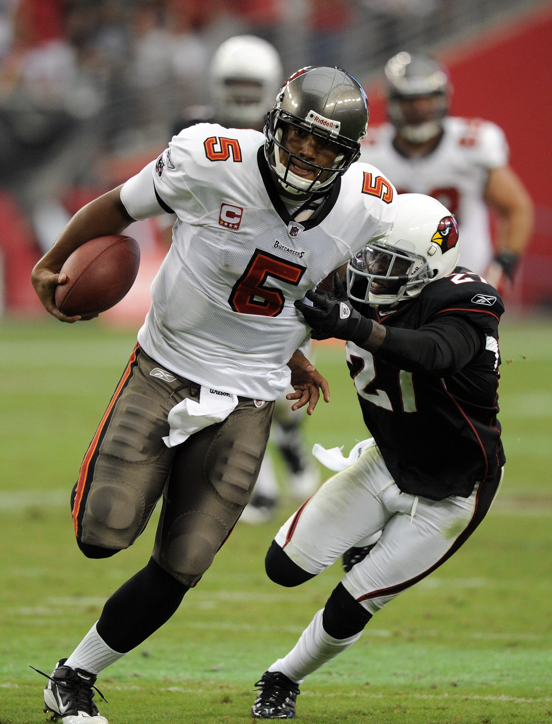 GLENDALE, AZ - OCTOBER 31:  Josh Freeman #5 of the Tampa Bay Buccaneers breaks the tackle of Michael Adams #27 of the Arizona Cardinals at University of Phoenix Stadium on October 31, 2010 in Glendale, Arizona.  (Photo by Harry How/Getty Images)