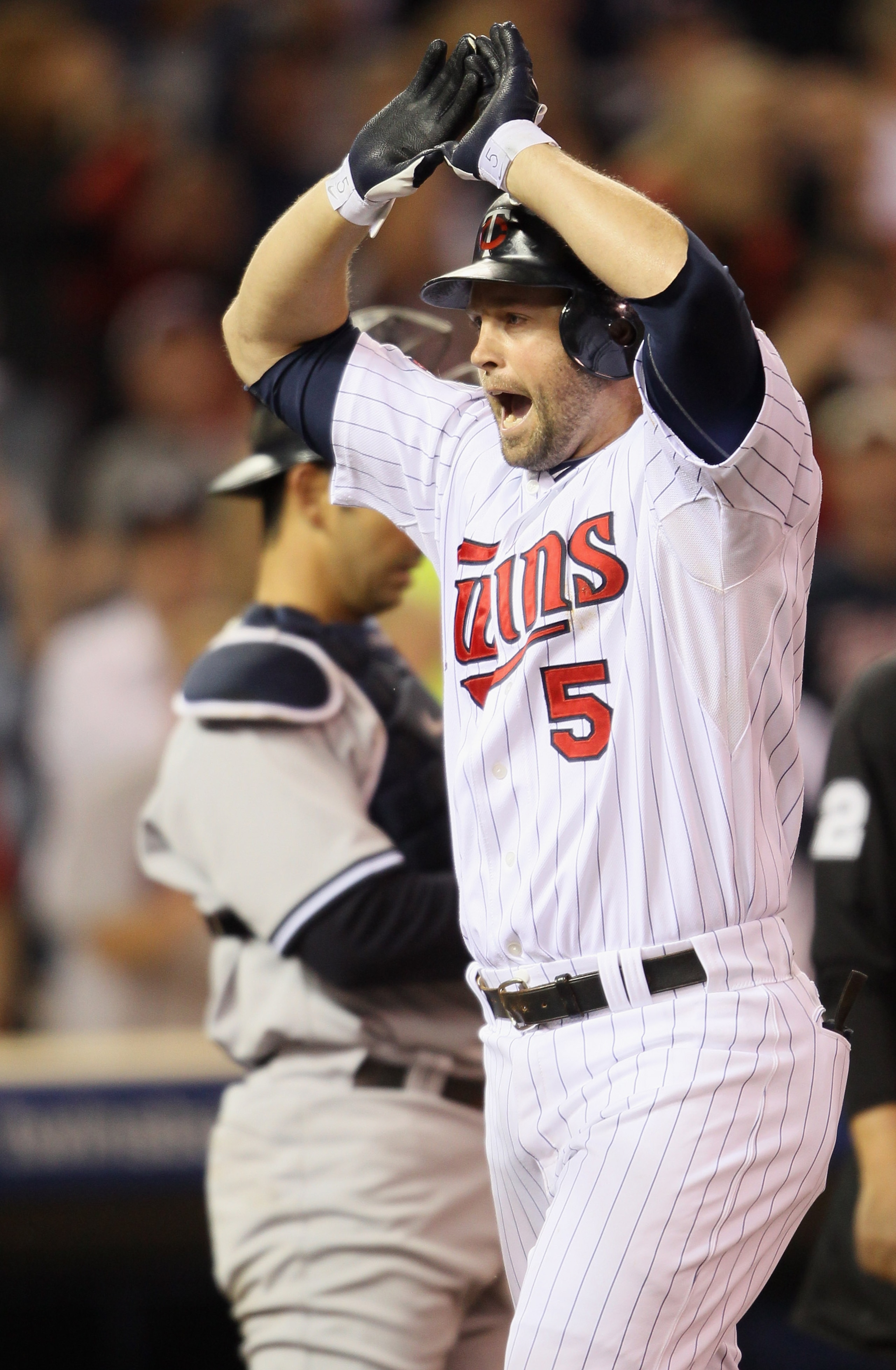 MINNEAPOLIS - OCTOBER 06:  Michael Cuddyer #5 of the Minnesota Twins celebrates his two run homer as Jorge Posada #20 of the New York Yankees stands by during game one of the ALDS on October 6, 2010 at Target Field in Minneapolis, Minnesota.  (Photo by El