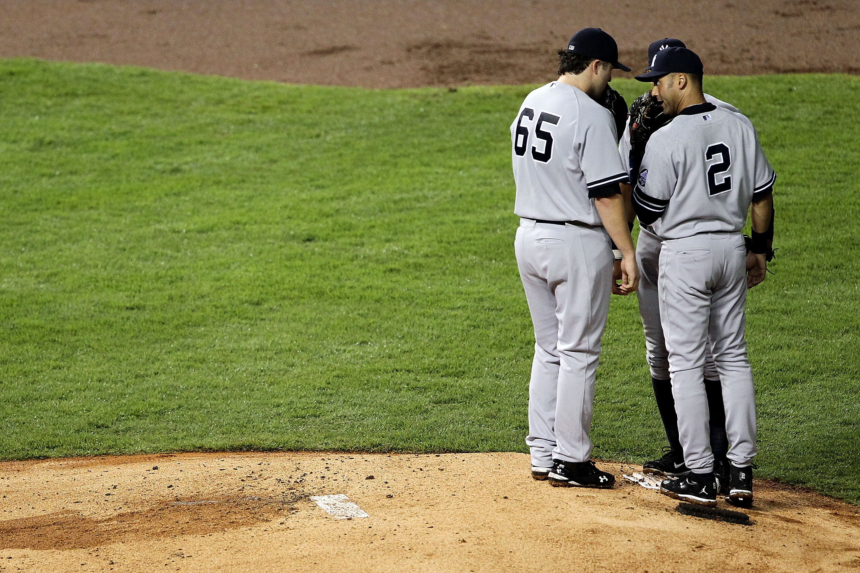 ARLINGTON, TX - OCTOBER 22:  Derek Jeter #2 of the New York Yankees speaks with Phil Hughes #65 on the mound in Game Six of the ALCS against the Texas Rangers during the 2010 MLB Playoffs at Rangers Ballpark in Arlington on October 22, 2010 in Arlington, 