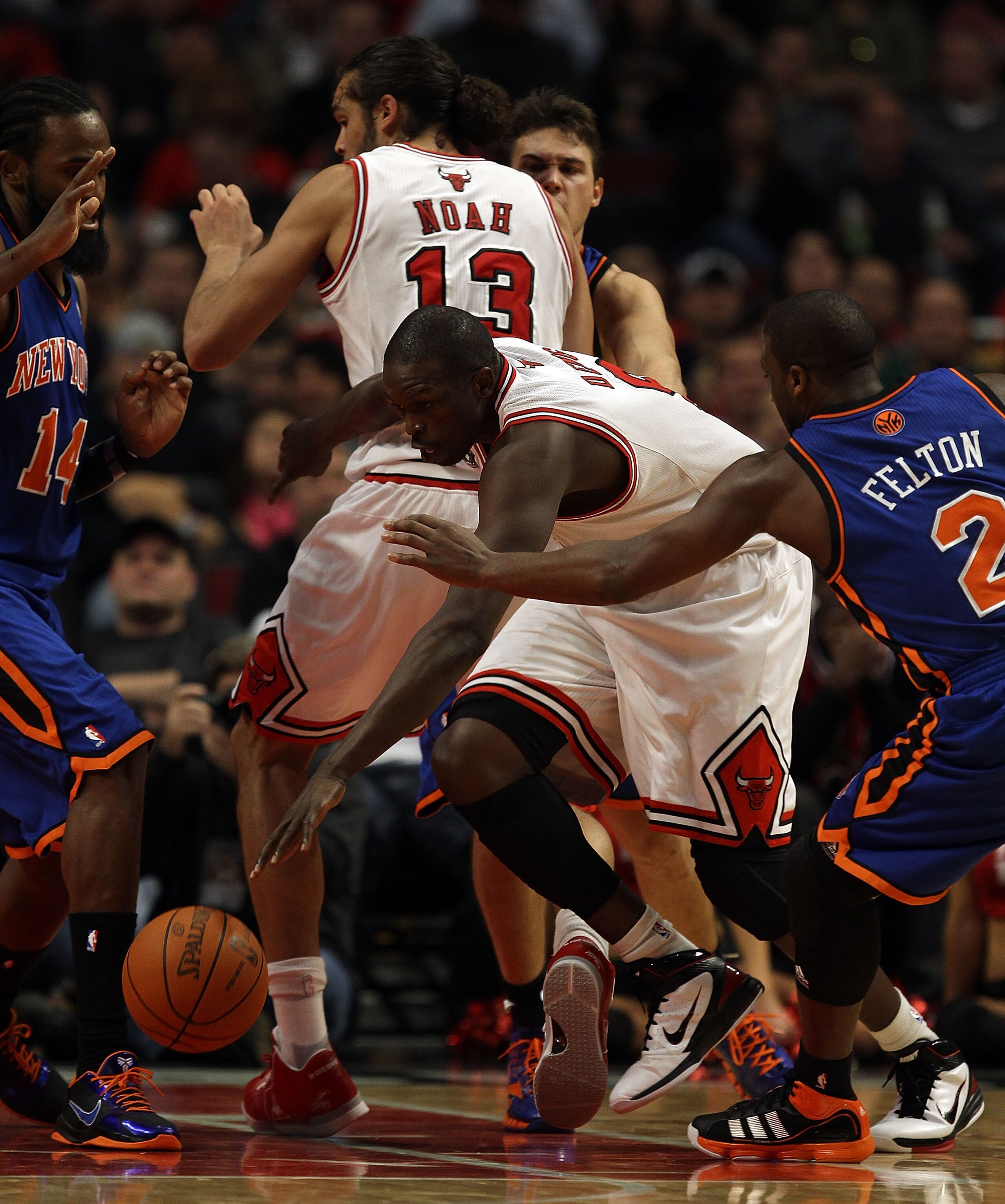 CHICAGO - NOVEMBER 04: Loul Deng #9 of the Chicago Bulls drives between teammate Joakim Noah #13 and Raymond Felton #2 of the New York Knicks at the United Center on November 4, 2010 in Chicago, Illinois. The Knicks defeated the Bulls 120-112. NOTE TO USE