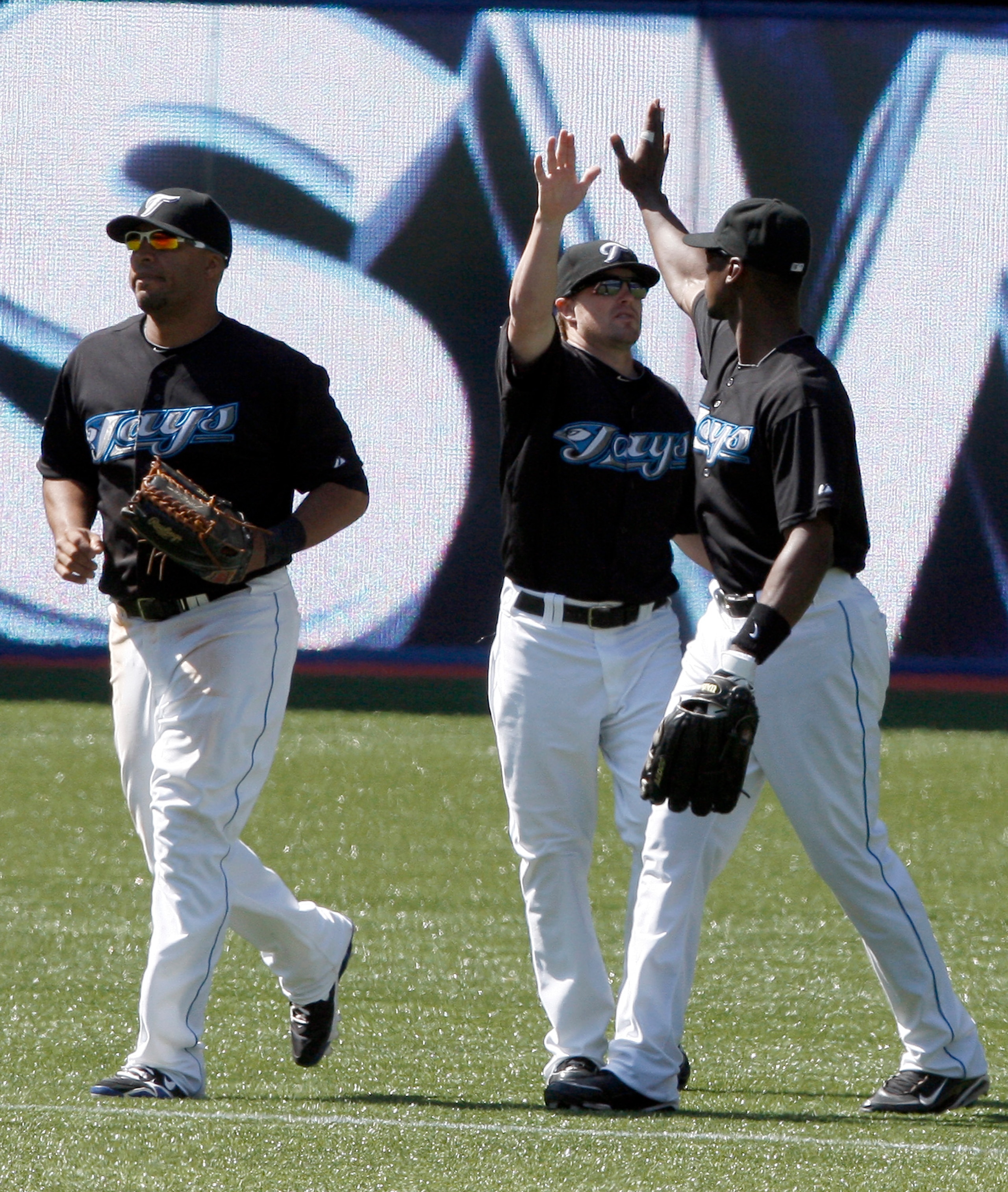 TORONTO - MAY 16: Vernon Wells #10, Mike McCoy #18 and Fred Lewis #15 of the Toronto Blue Jays celebrate sweep against the Texas Rangers during a MLB game at the Rogers Centre May 16, 2010 in Toronto, Ontario, Canada. (Photo by Abelimages/Getty Images)