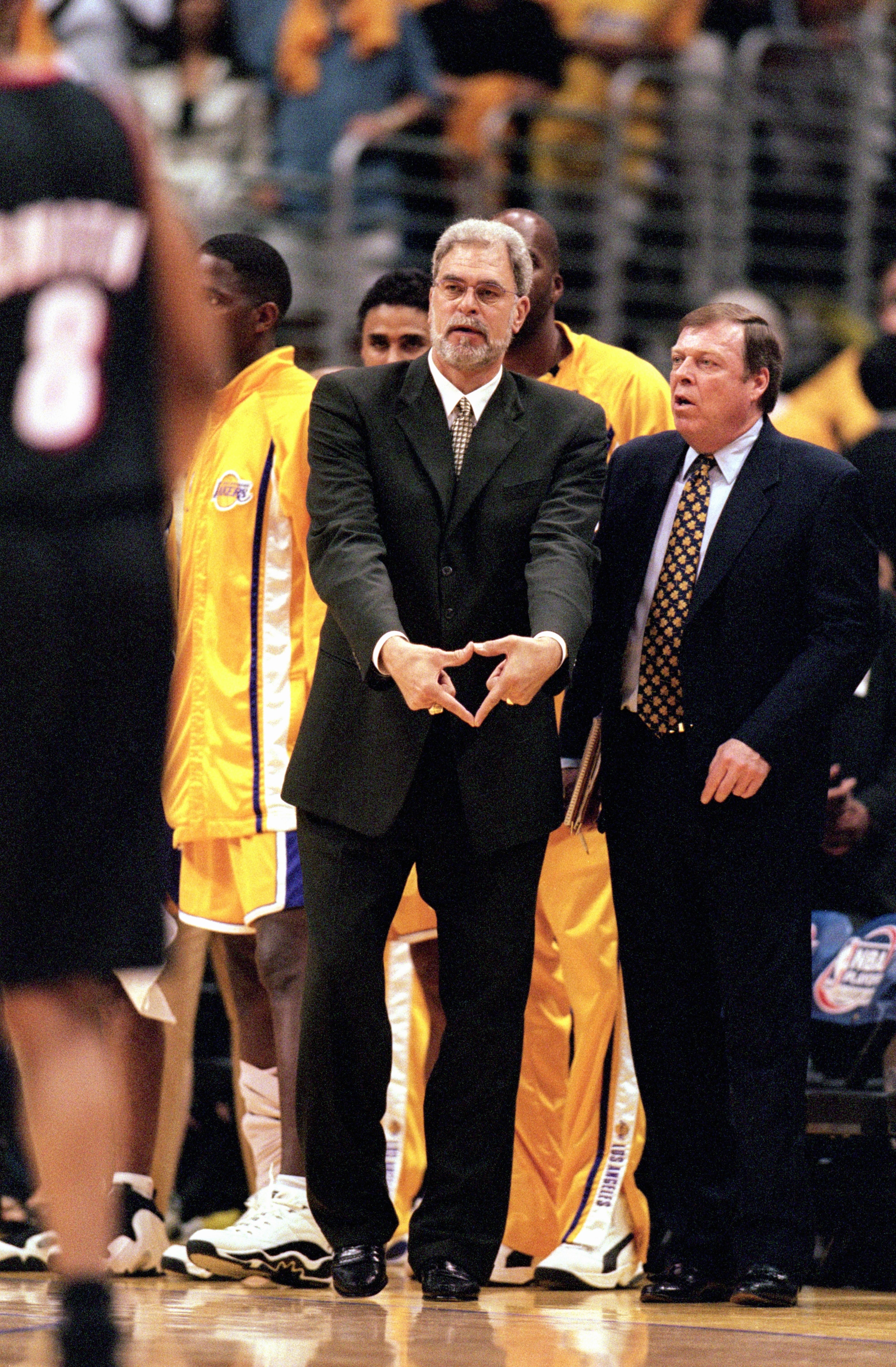 LOS ANGELES - JUNE 4:  Head coach Phil Jackson of the Los Angeles Lakers signals triangle defense as assistant coach Frank Hamblen looks on during Game 7 of the Western Conference Finals against the Portland Trail Blazers at Staples Center on June 4, 2000