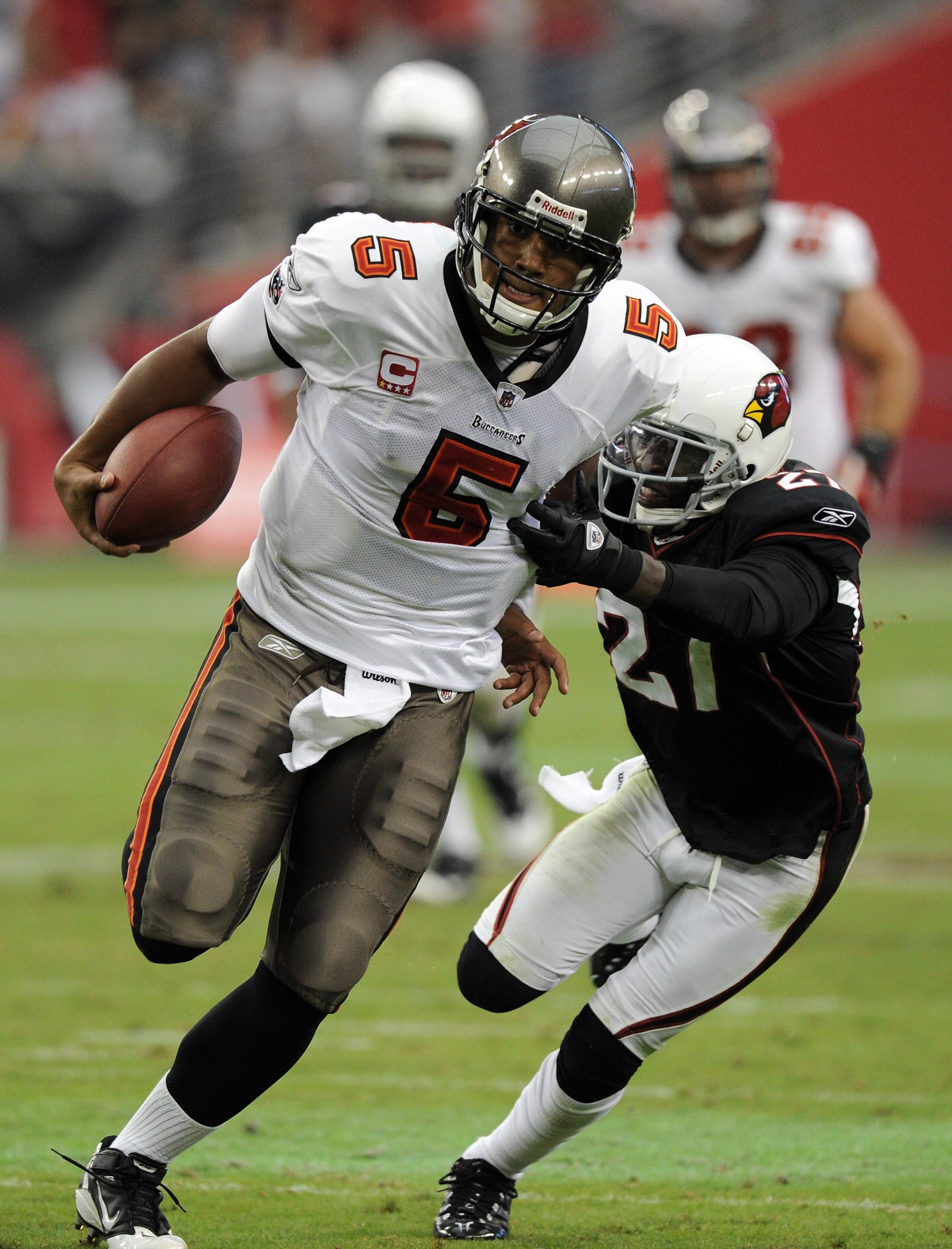 GLENDALE, AZ - OCTOBER 31:  Josh Freeman #5 of the Tampa Bay Buccaneers breaks the tackle of Michael Adams #27 of the Arizona Cardinals at University of Phoenix Stadium on October 31, 2010 in Glendale, Arizona.  (Photo by Harry How/Getty Images)