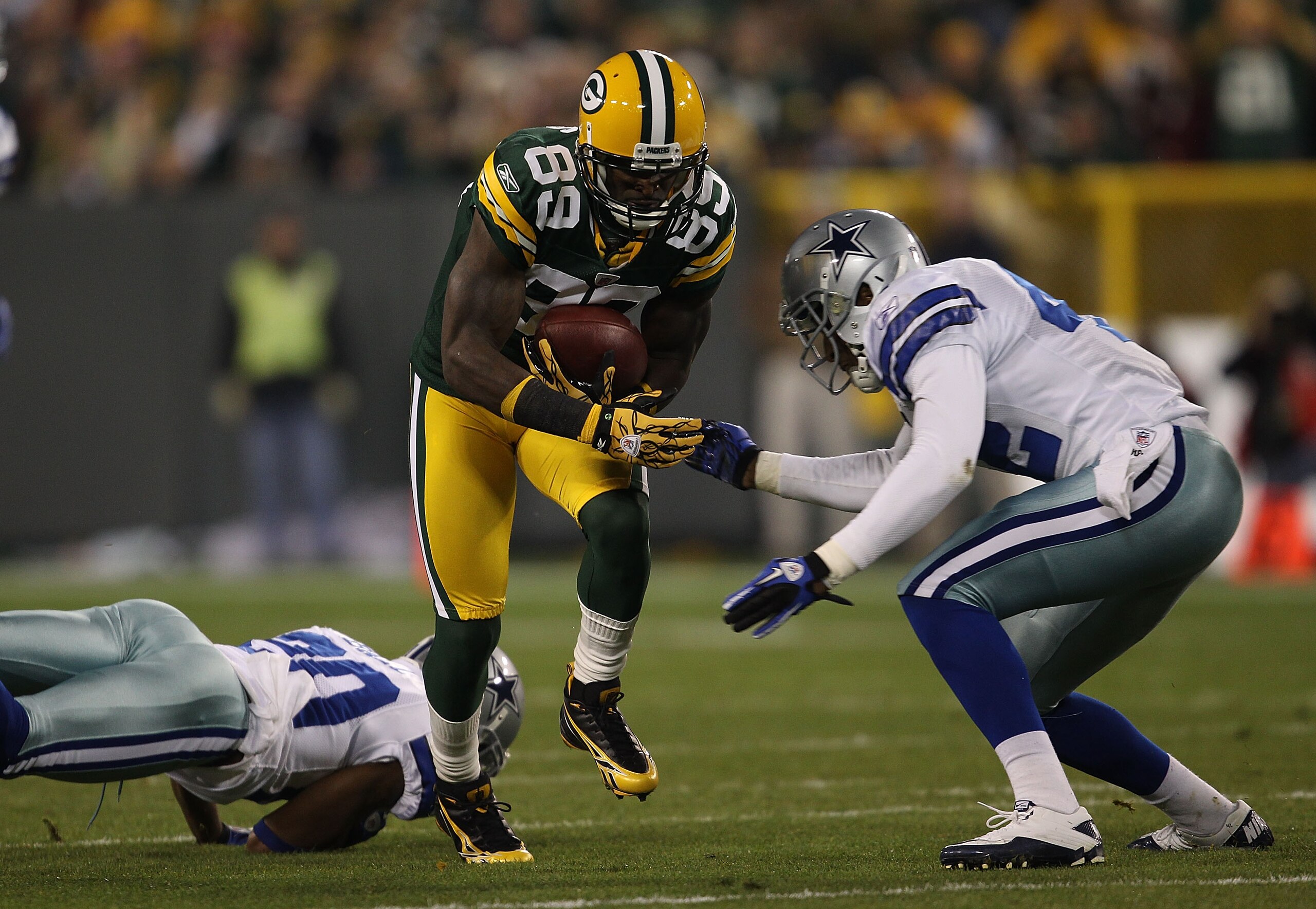 GREEN BAY, WI - NOVEMBER 07: James Jones #89 of the Green Bay Packers runs past Alan Ball #20 of the Dallas Cowboys as Barry Church #42 moves in for the tackle at Lambeau Field on November 7, 2010 in Green Bay, Wisconsin. The Packers defeated the Cowboys