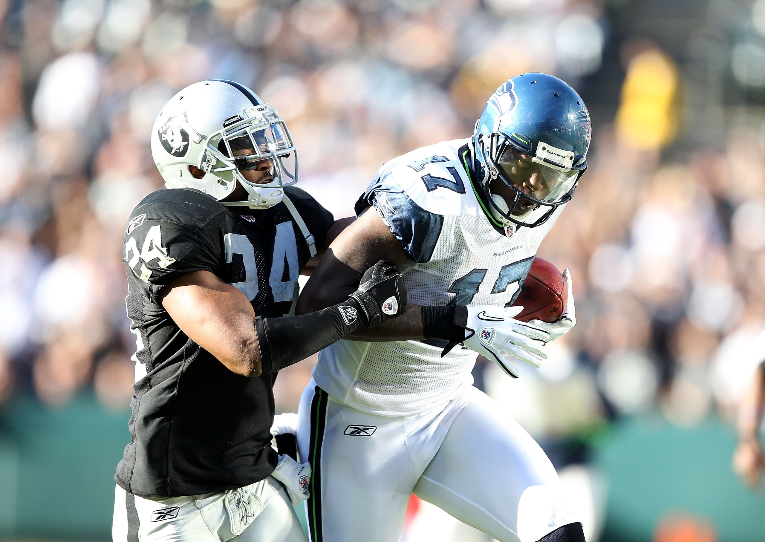OAKLAND, CA - OCTOBER 31:  Mike Williams #17 of the Seattle Seahawks catches the ball while defended by Michael Huff #24 of the Oakland Raiders at Oakland-Alameda County Coliseum on October 31, 2010 in Oakland, California.  (Photo by Ezra Shaw/Getty Image