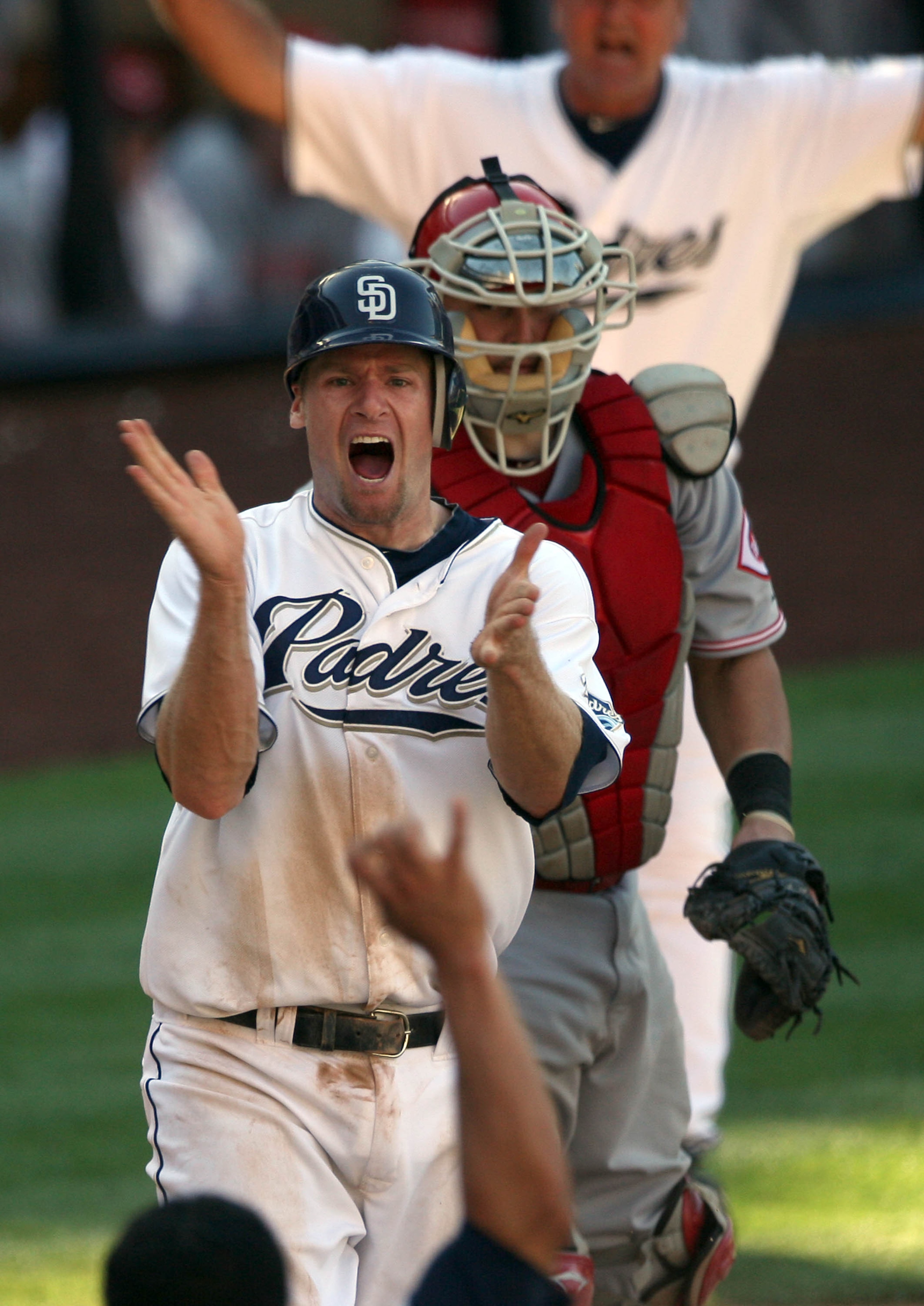 SAN DIEGO, CA - SEPTEMBER 25:  Chase Headley #7 of the San Diego Padres slides past the tag of catcher Ramon Hernandez #55 of the Cincinnati Reds for the winning score during the Padres 4-3 win in their MLB game on September 25, 2010 at PETCO Park in San 