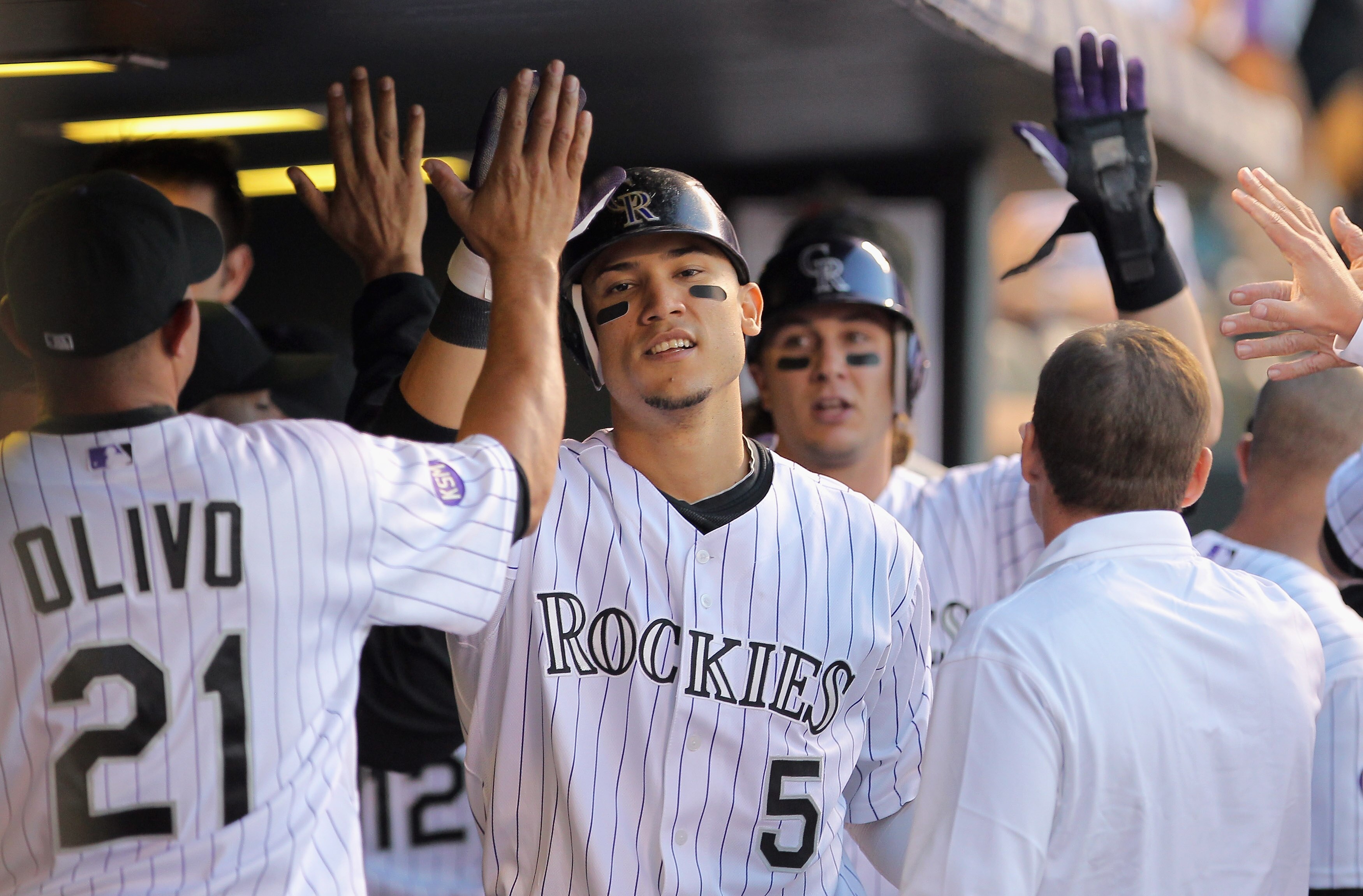 DENVER - SEPTEMBER 25:  Carlos Gonzalez #5 and Troy Tulowitzki #2 of the Colorado Rockies celebrate in the dugout after scoring on a Melvin Mora single to give the Rockies a 2-1 lead over the San Francisco Giants in the first inning at Coors Field on Sept
