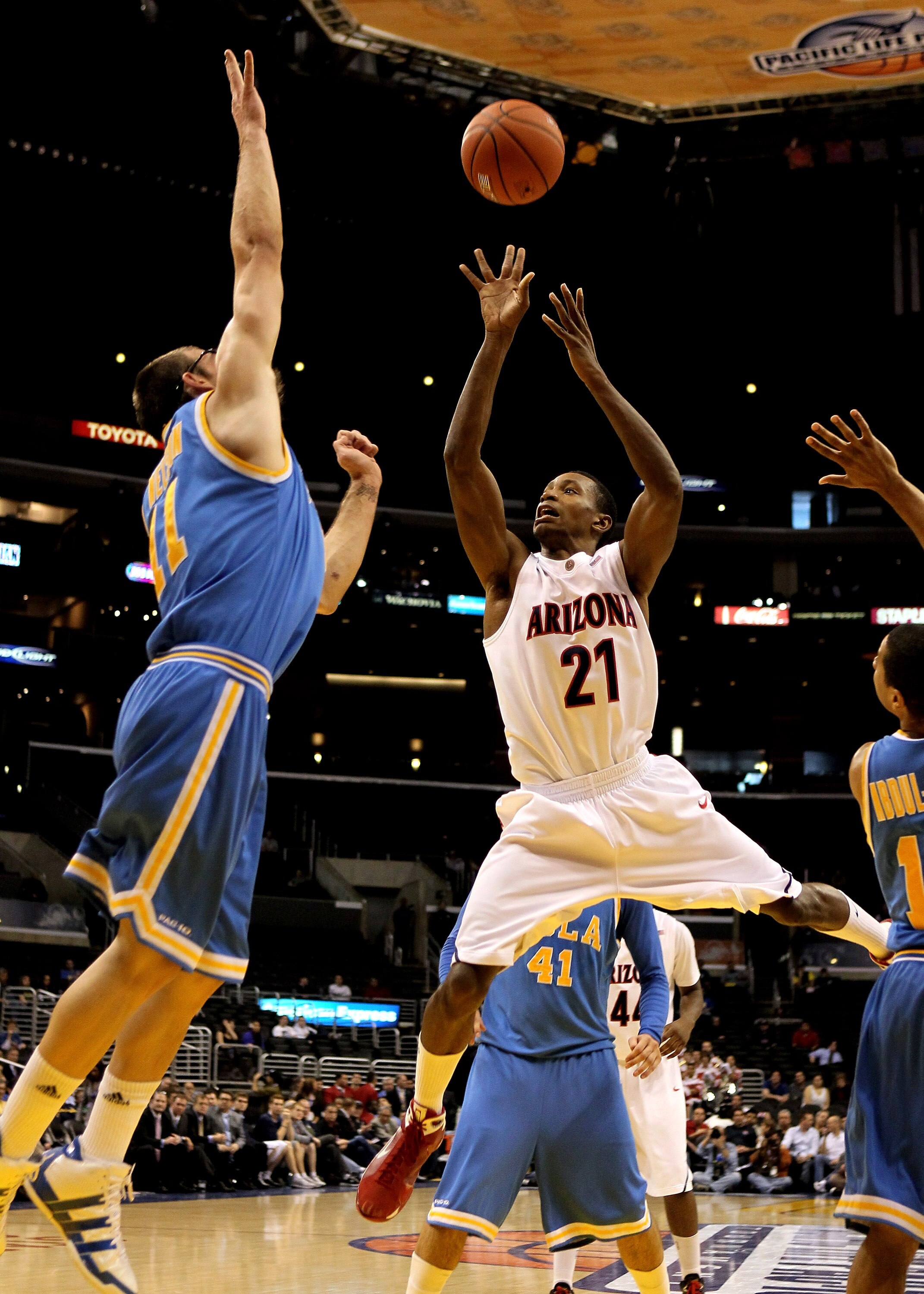 LOS ANGELES, CA - MARCH 11:  Kyle Fogg #21 of the Arizona Wildcats shoots over Reeves Nelson #11 of the UCLA Bruins during the quarterfinals of the Pac-10 Basketball Tournament at Staples Center on March 11, 2010 in Los Angeles, California.  (Photo by Ste