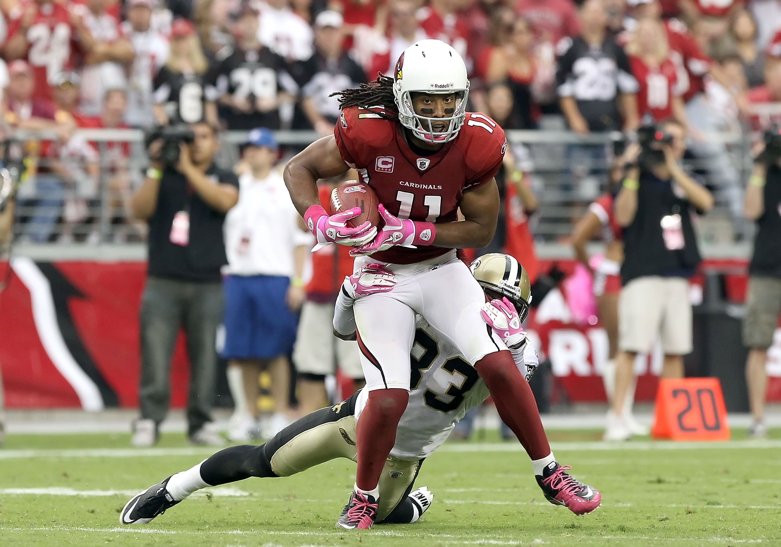 GLENDALE, AZ - OCTOBER 10:  Wide receiver Larry Fitzgerald #11 of the Arizona Cardinals runs with the football after a reception past Jabari Greer #33 of the New Orleans Saints during the NFL game at the University of Phoenix Stadium on October 10, 2010 i