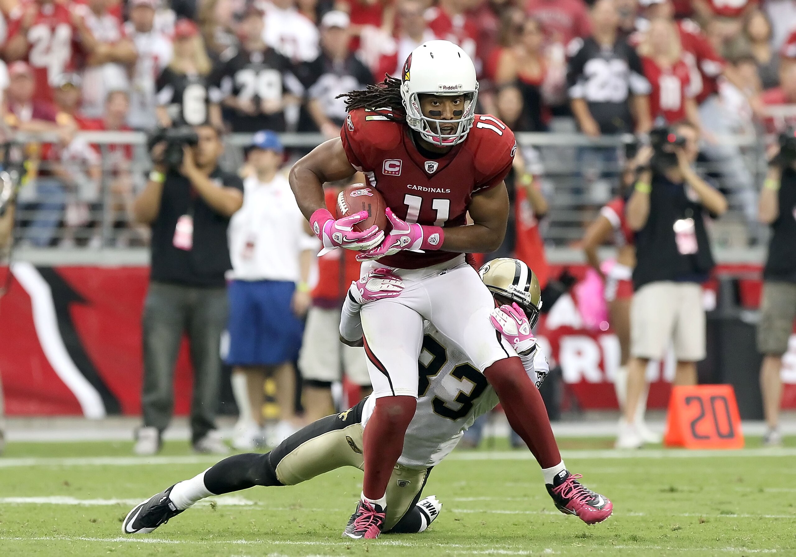 GLENDALE, AZ - OCTOBER 10:  Wide receiver Larry Fitzgerald #11 of the Arizona Cardinals runs with the football after a reception past Jabari Greer #33 of the New Orleans Saints during the NFL game at the University of Phoenix Stadium on October 10, 2010 i