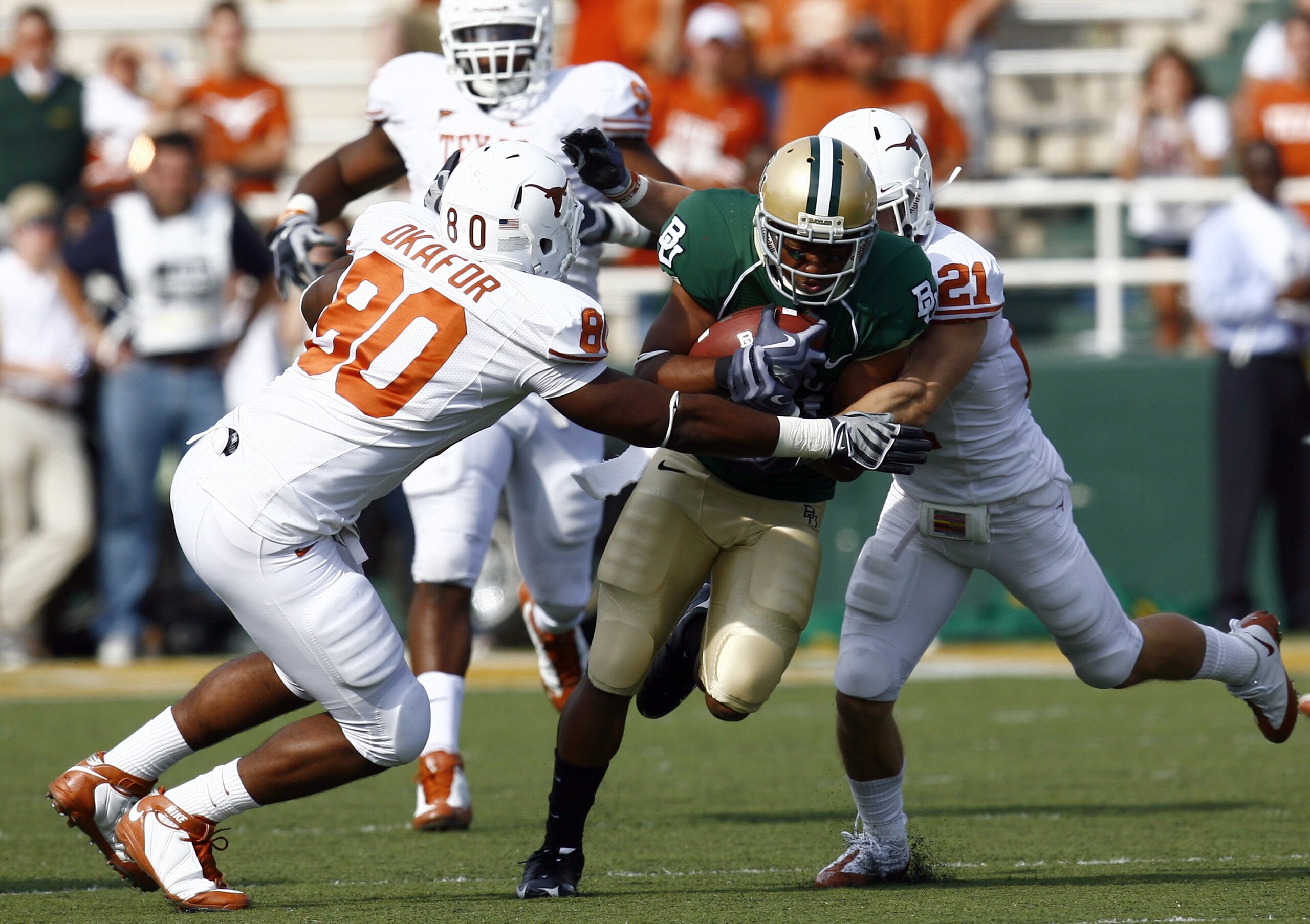 WACO, TX - NOVEMBER 14: Running back Jarred Salubi #21 of the Baylor Bears carries the ball during in the second half against defensive end Alex Okafor #80 and safety Blake Gideon #21 of the Texas Longhorns on November 14, 2009 at Floyd Casey Stadium in WACO, TX - NOVEMBER 14: Running back Jarred Salubi #21 of the Baylor Bears carries the ball during in the second half against defensive end Alex Okafor #80 and safety Blake Gideon #21 of the Texas Longhorns on November 14, 2009 at Floyd Casey Stadium in