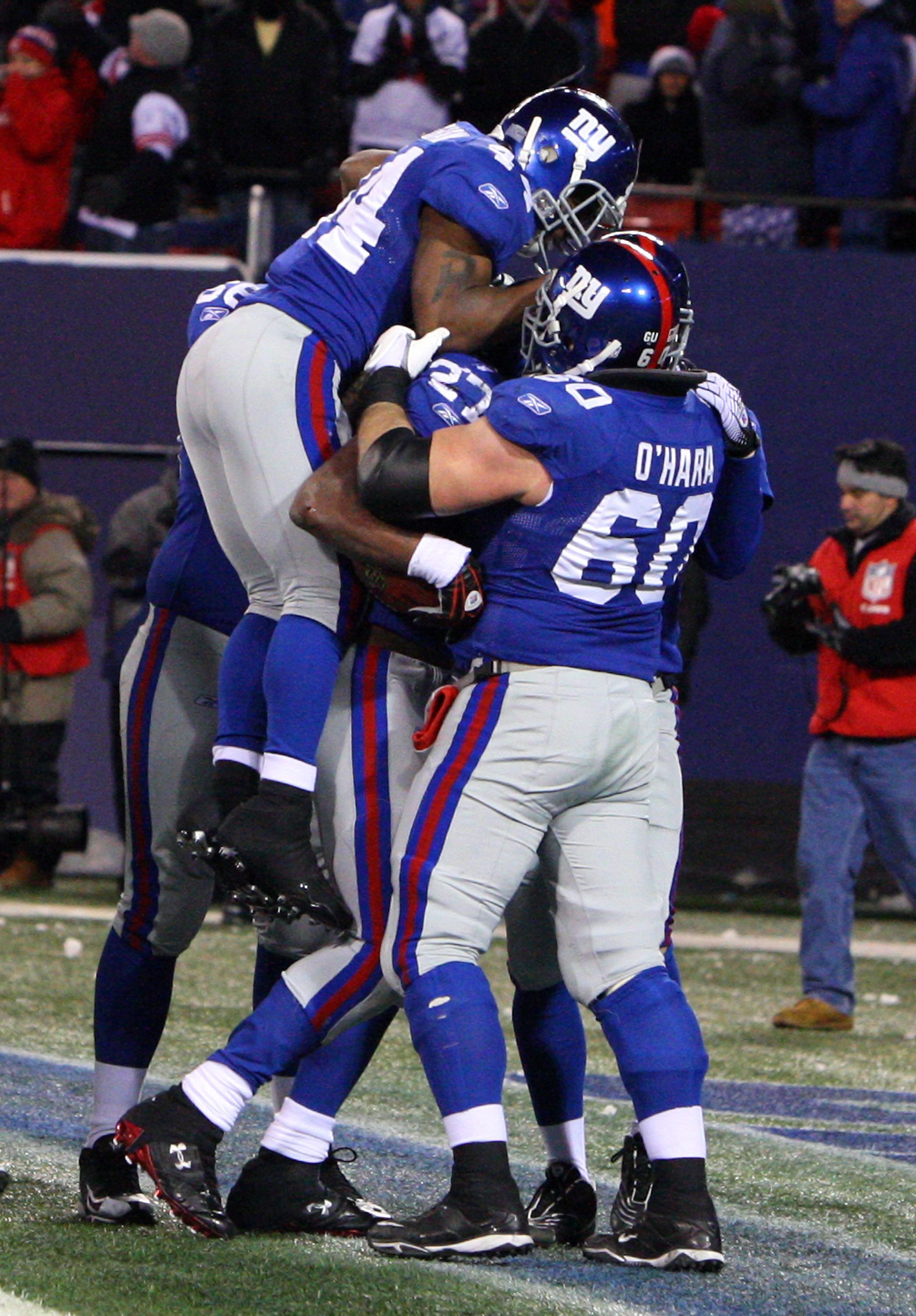 EAST RUTHERFORD, NJ - DECEMBER 21:  Running back Brandon Jacobs #27 of the New York Giants celebrates with teammates Derrick Ward #34 and Shaun O'Hara #60 in the end zone after scoring a touchdown against the Carolina Panthers in over time on December 21,