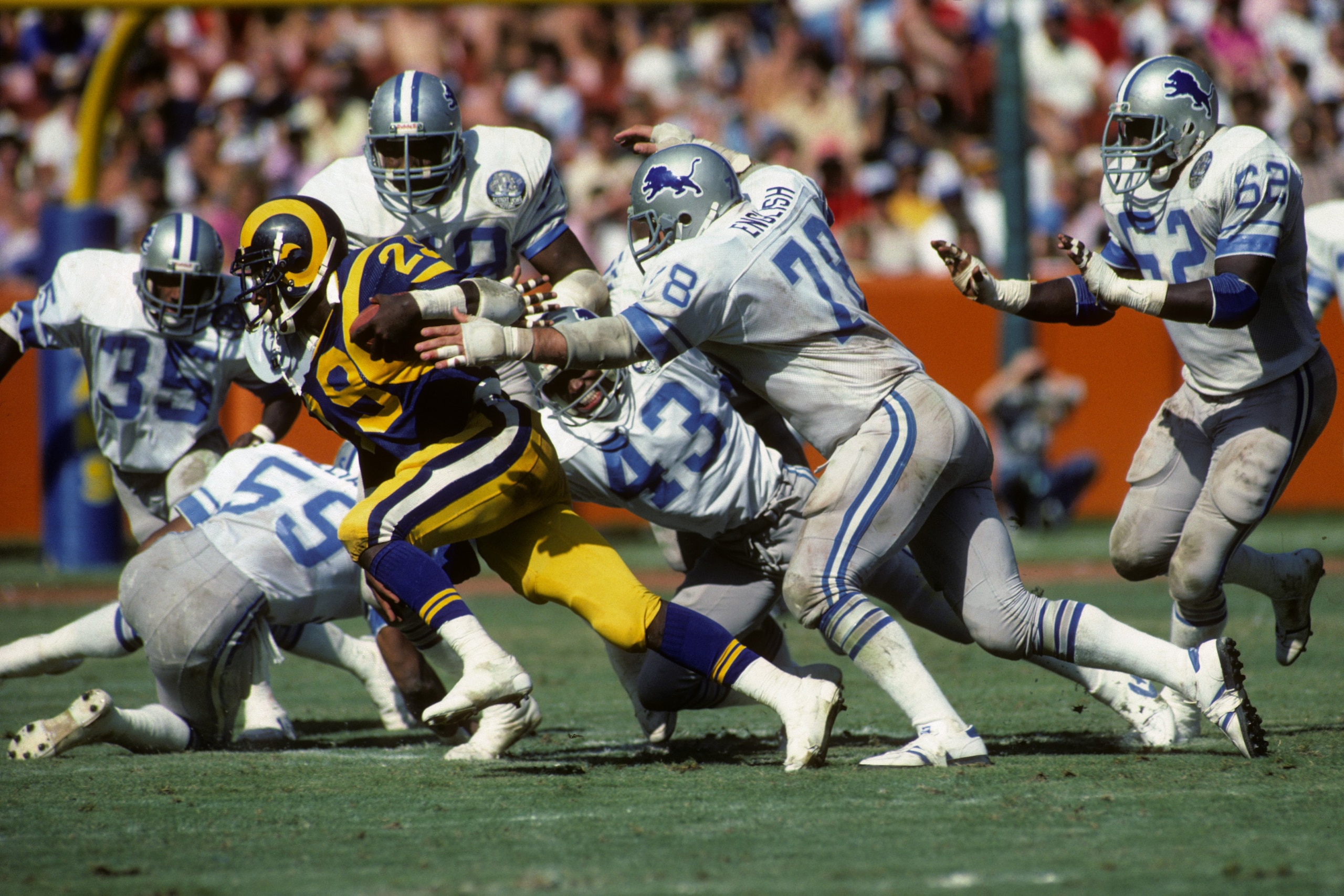 ANAHEIM, CA - OCTOBER 2:  Running back Eric Dickerson #29 of the Los Angeles Rams tries to escape from defensive tackle Doug English #78 of the Detroit Lions during the game at Anaheim Stadium on Ocotber 2, 1983 in Anaheim, California.  The Rams won 21-10