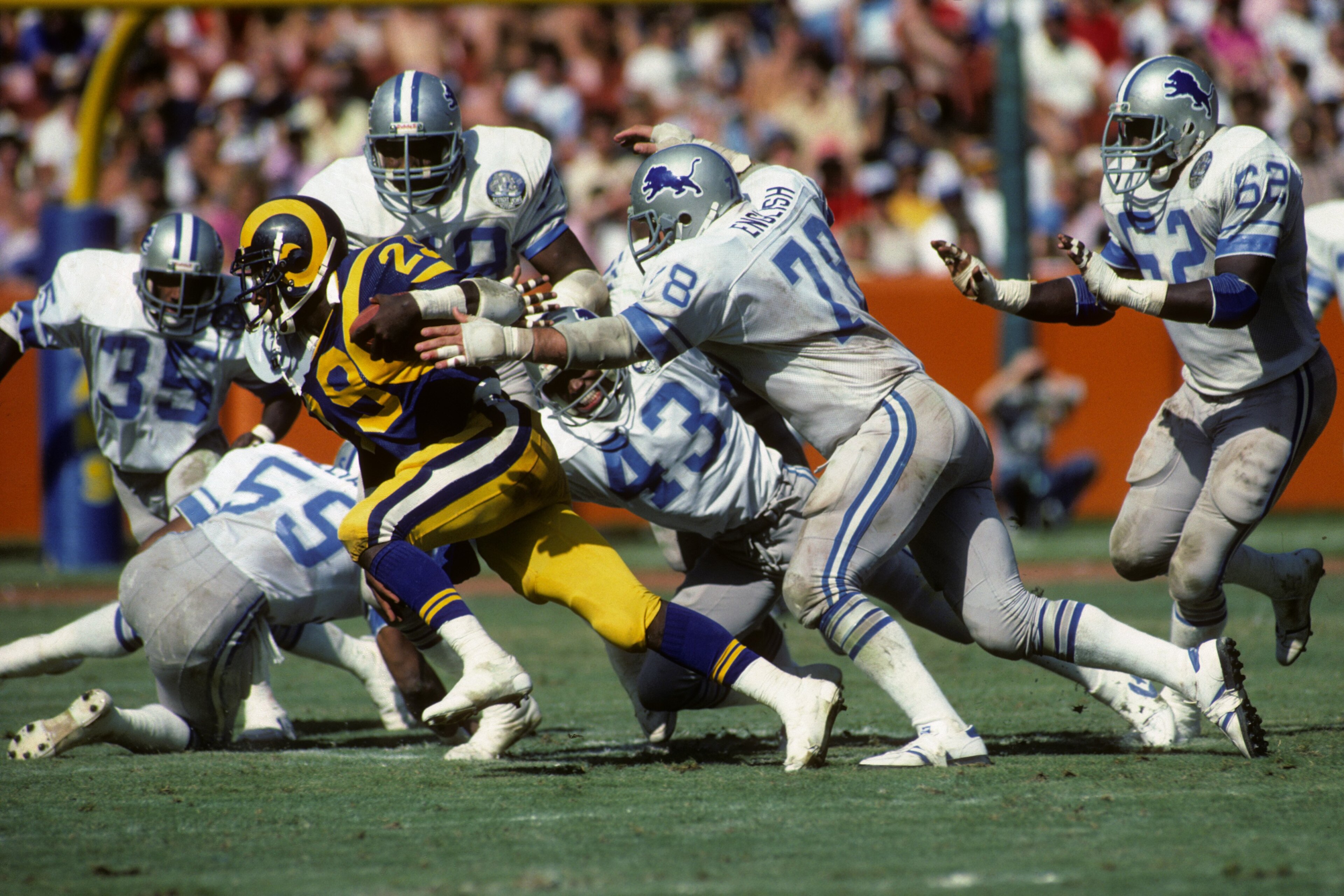 ANAHEIM, CA - OCTOBER 2:  Running back Eric Dickerson #29 of the Los Angeles Rams tries to escape from defensive tackle Doug English #78 of the Detroit Lions during the game at Anaheim Stadium on Ocotber 2, 1983 in Anaheim, California.  The Rams won 21-10